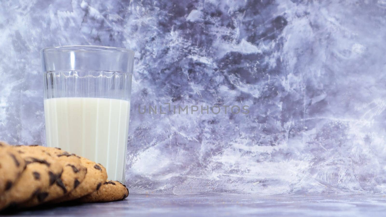 American gluten free chocolate chip cookies with glass glass of vegetable milk on gray background. Chocolate chip cookies. Sweet pastries, dessert. Culinary background. Copy space.