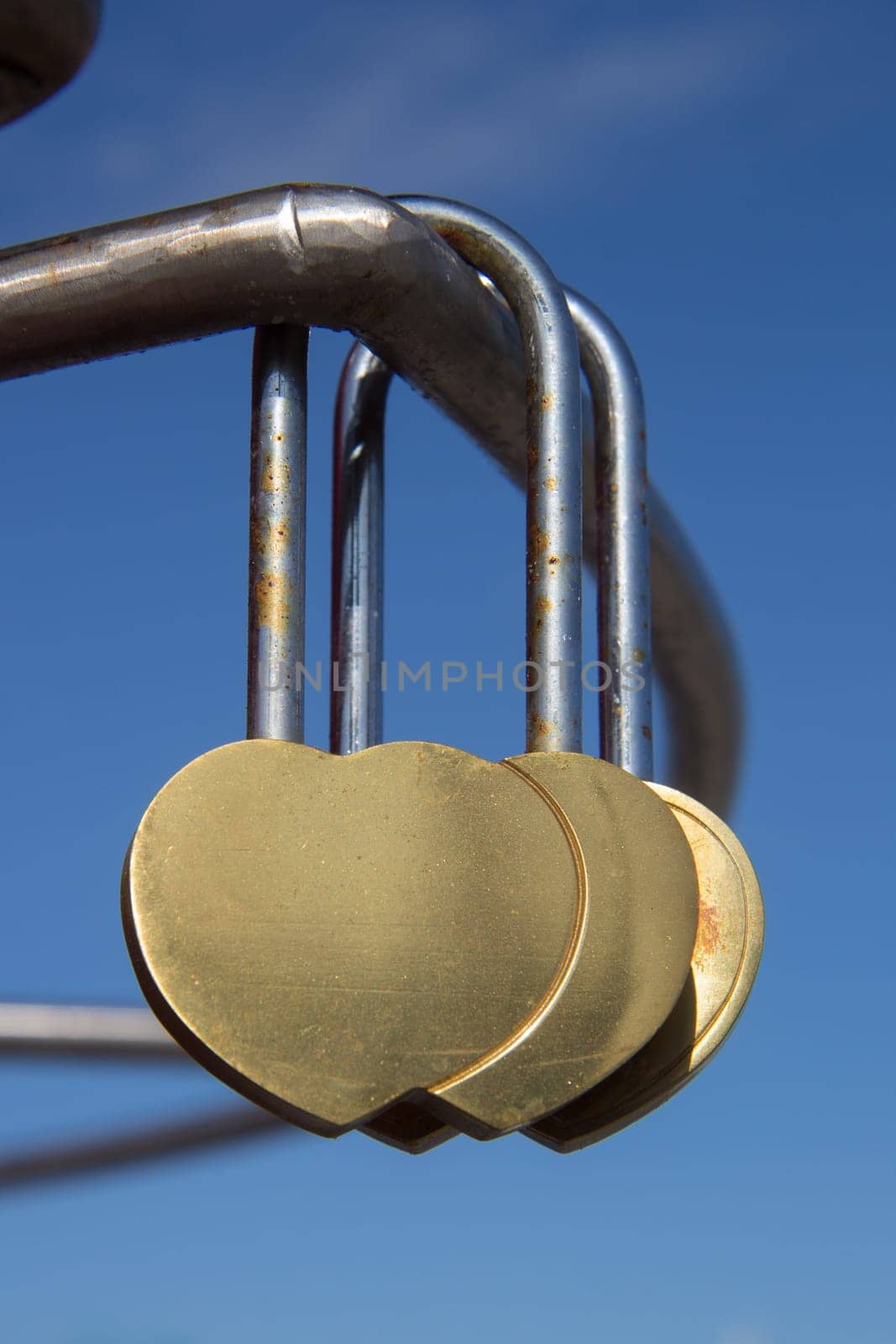 Heart shaped locks hanging over blue sky
