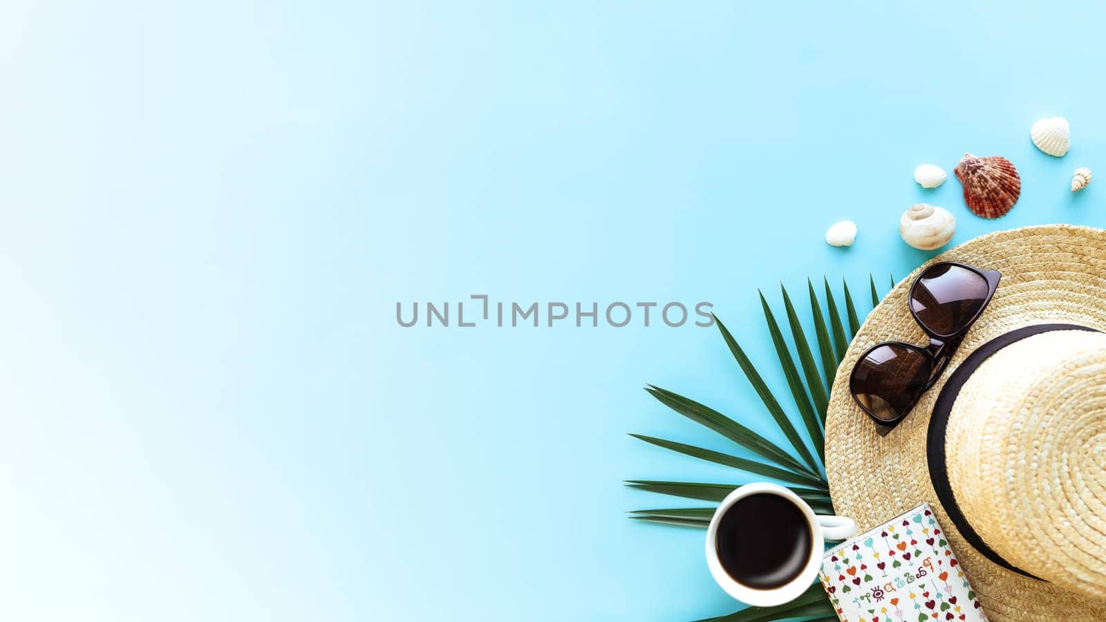 Travel, vacation concept. Hat with different sea shells, green palm leaf, passport, eyeglasses and cup of coffee on blue sky background. Travelling to warm countries. Banner with copy space for text
