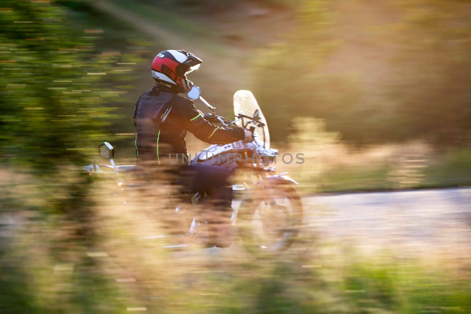 Motorcycle driver driving in beautiful sunset.