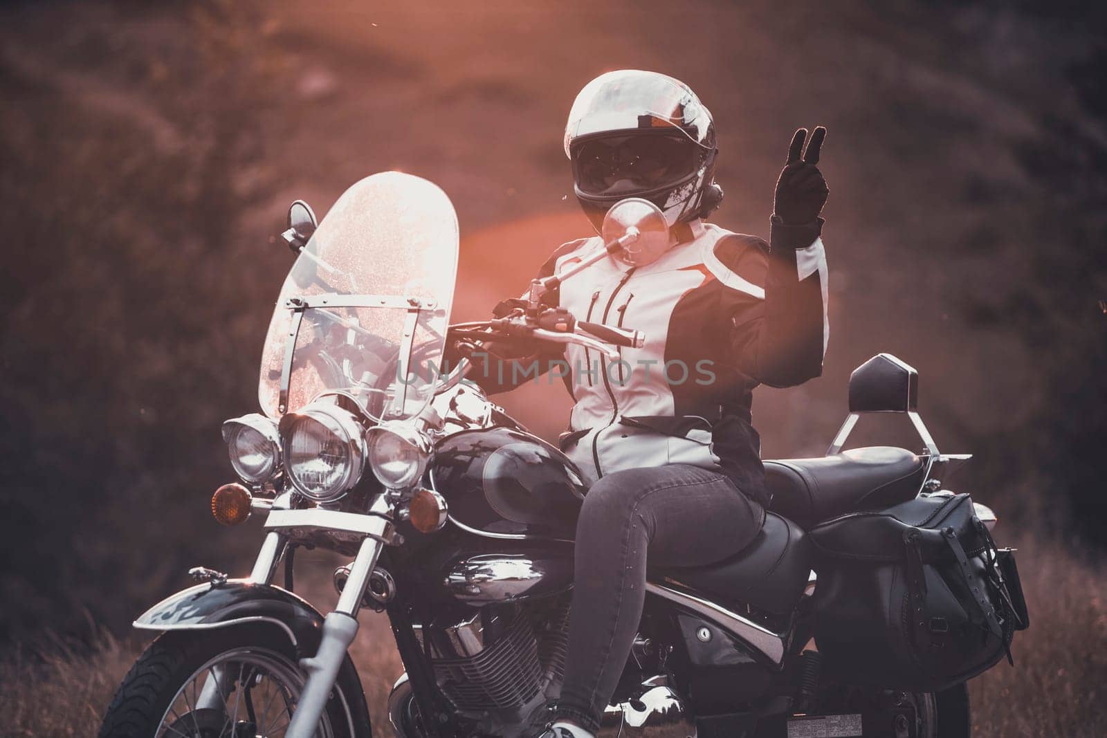 Biker girl on a motorcycle in the sunset.