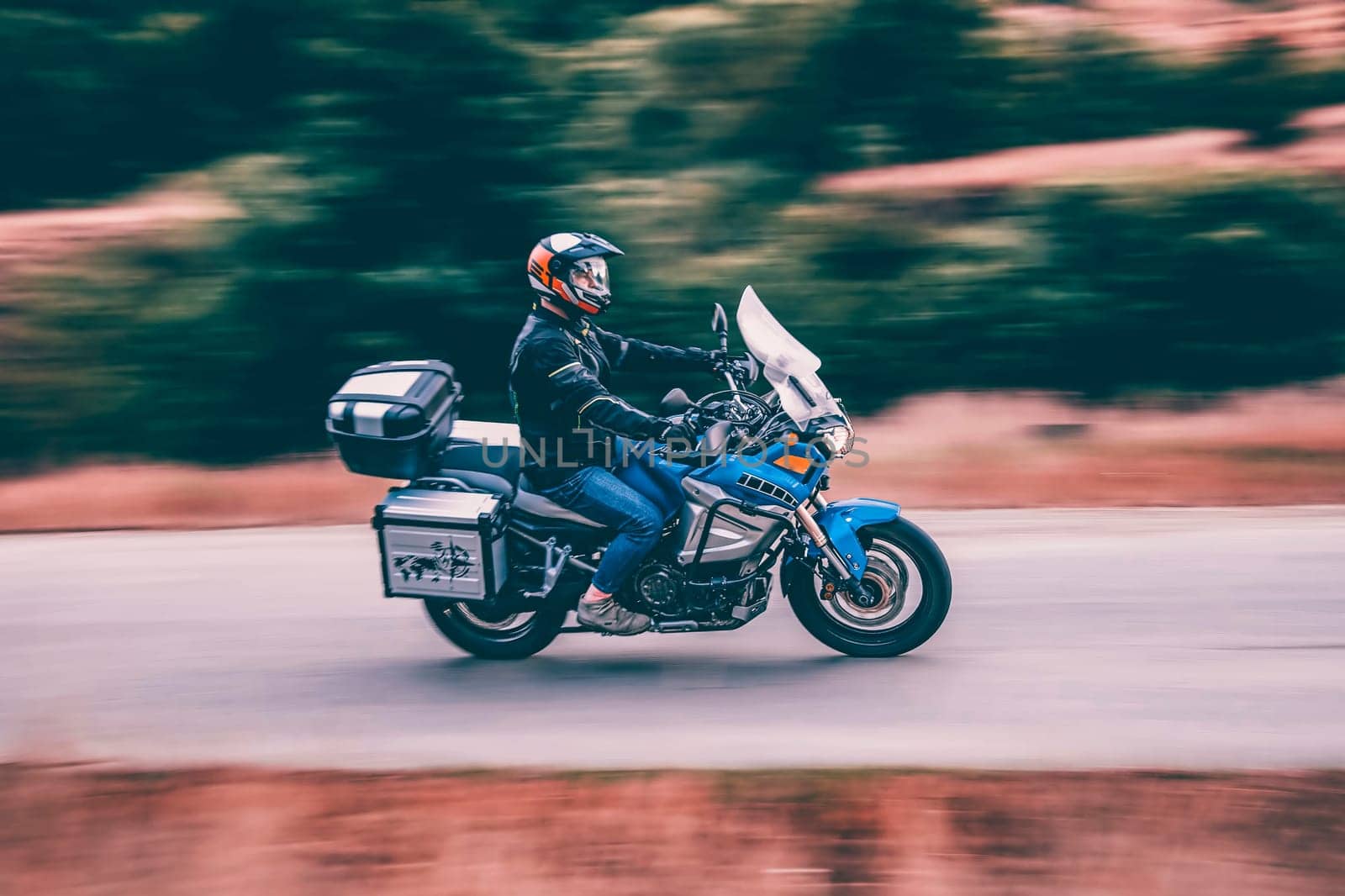 Motorcycle driver driving in beautiful sunset.