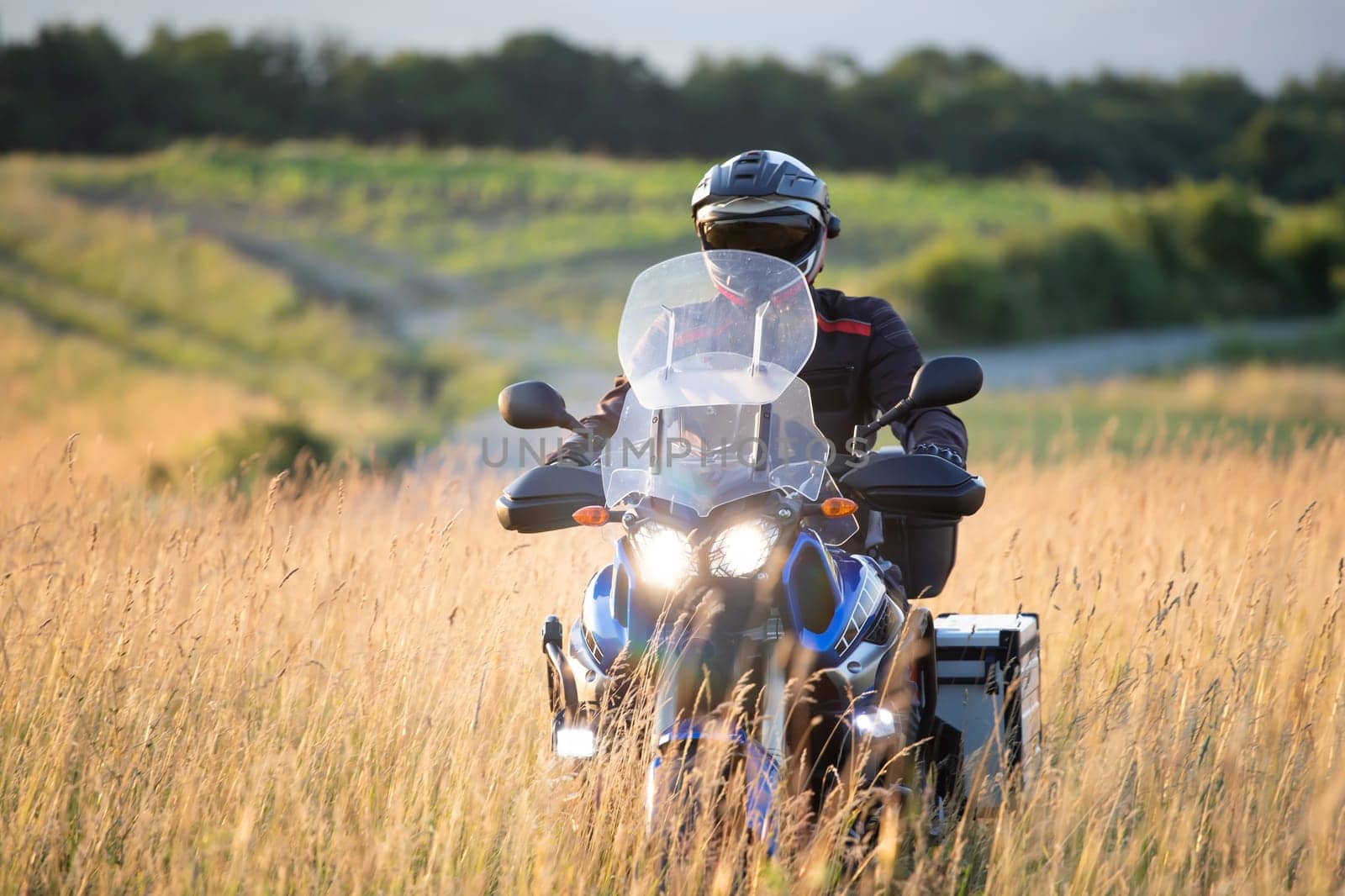 Motorcycle driver riding on countryside hills. Travel and sport, speed and freedom concept