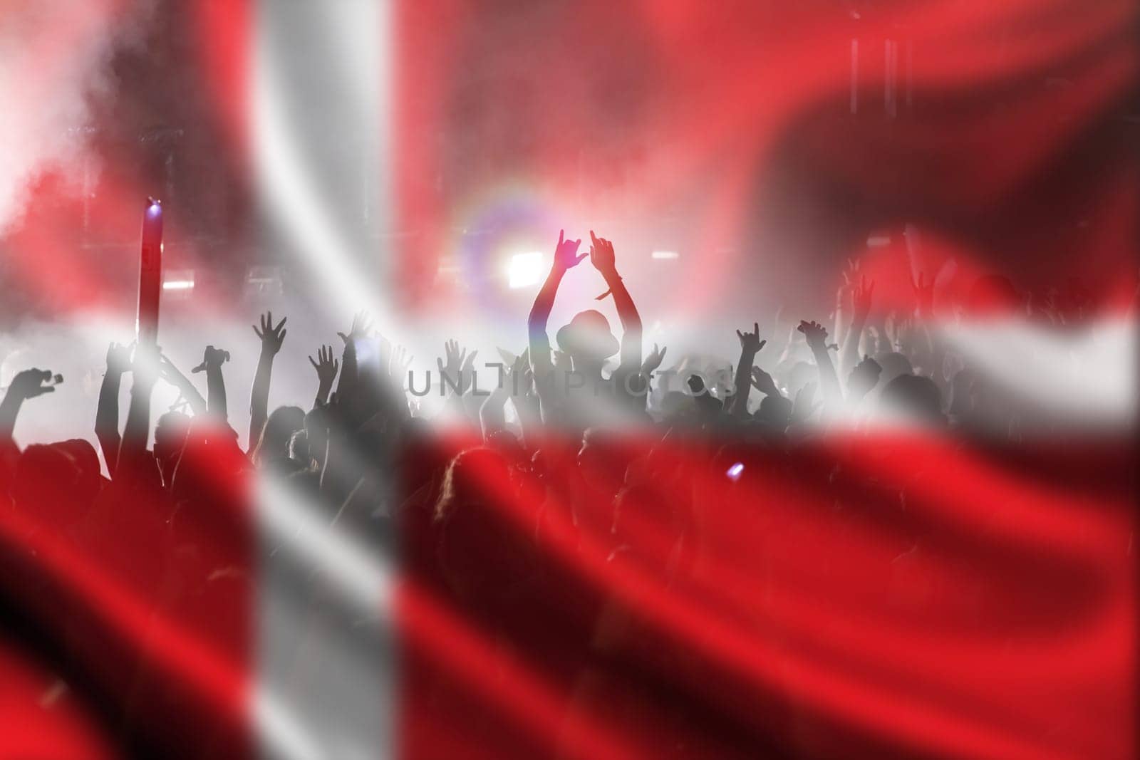 Soccer fans supporting Denmark - crowd celebrating in stadium with raised hands against Denmark flag