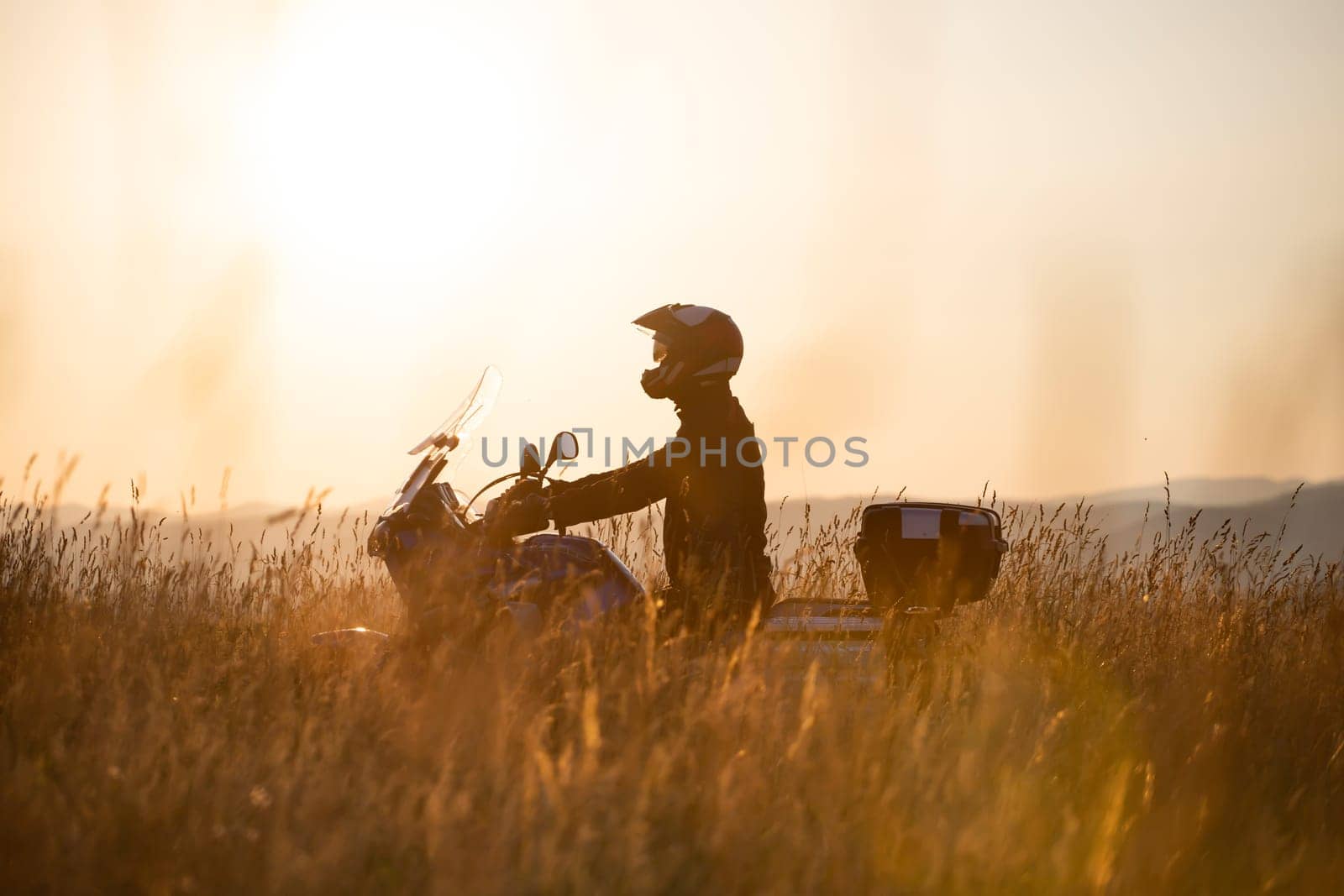 Motorcycle driver riding on countryside hills. Travel and sport, speed and freedom concept