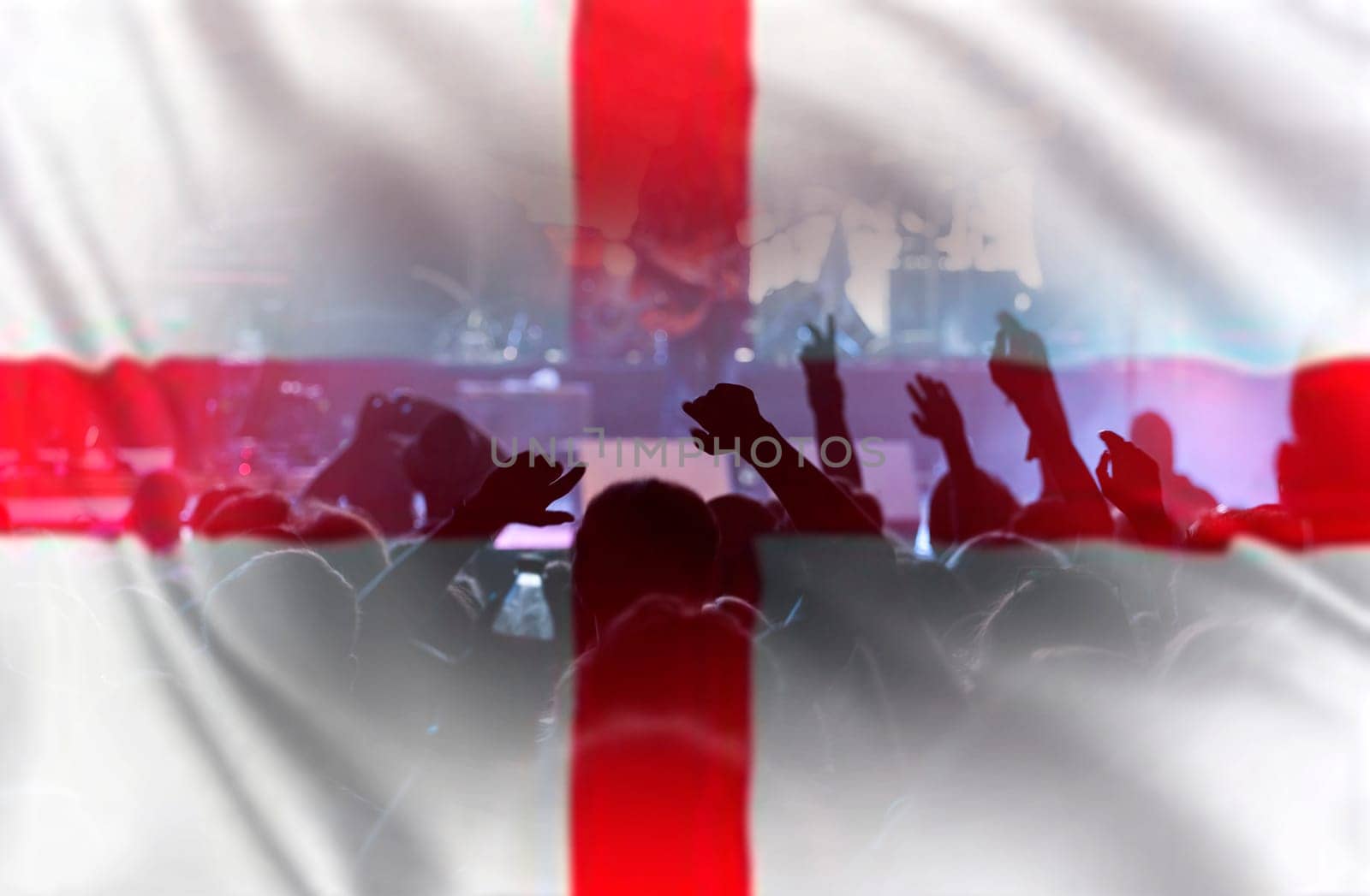 Football fans supporting England - crowd celebrating in stadium with raised hands against England flag