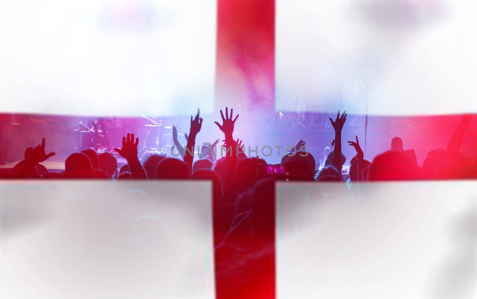 Football fans supporting England - crowd celebrating in stadium with raised hands against England flag