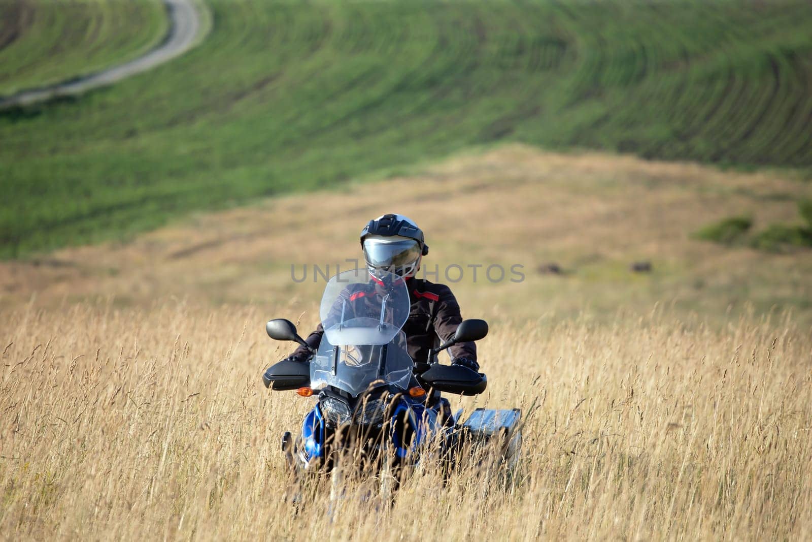 Motorcycle driver riding on countryside hills. Travel and sport, speed and freedom concept