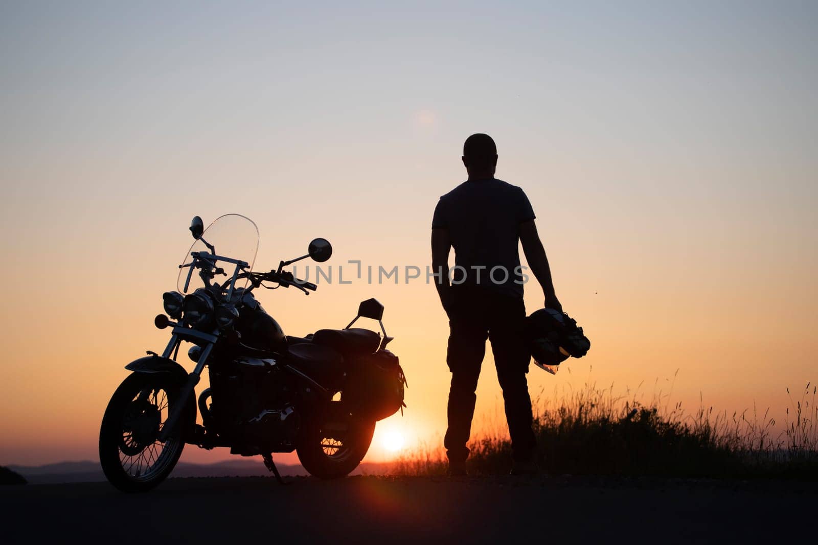 Motorcycle driver riding alone on asphalt motorway. Travel and sport, speed and freedom concept