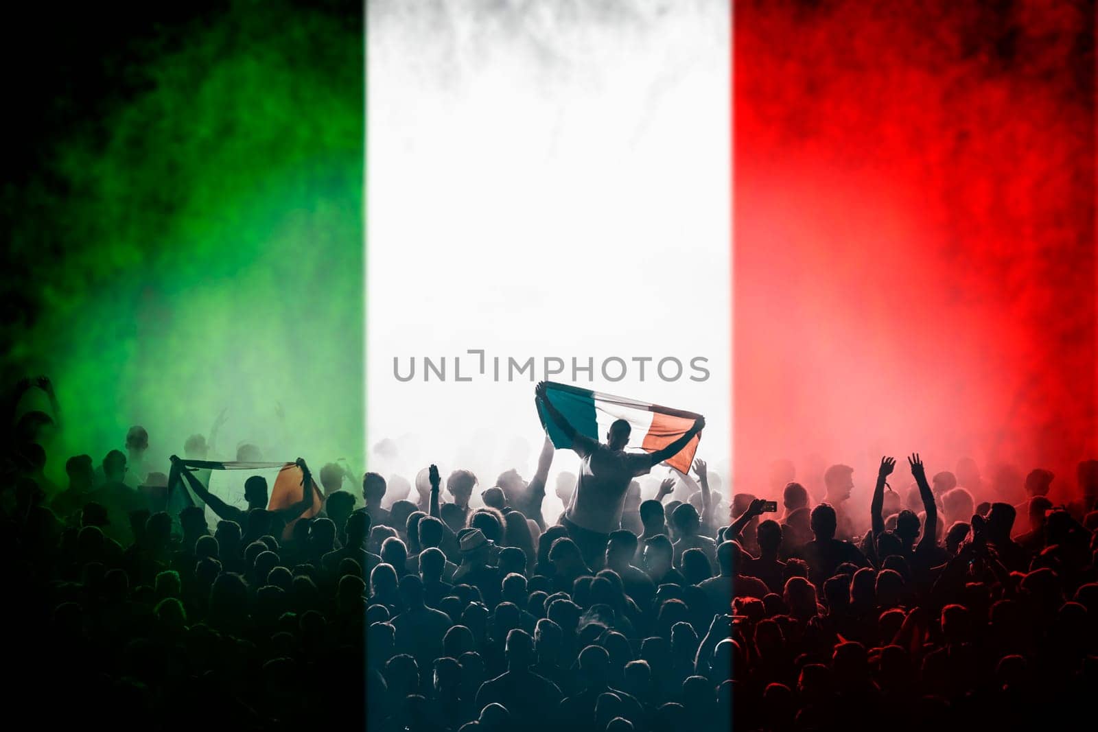 Soccer fans supporting Italy - crowd celebrating in stadium with raised hands against italian flag