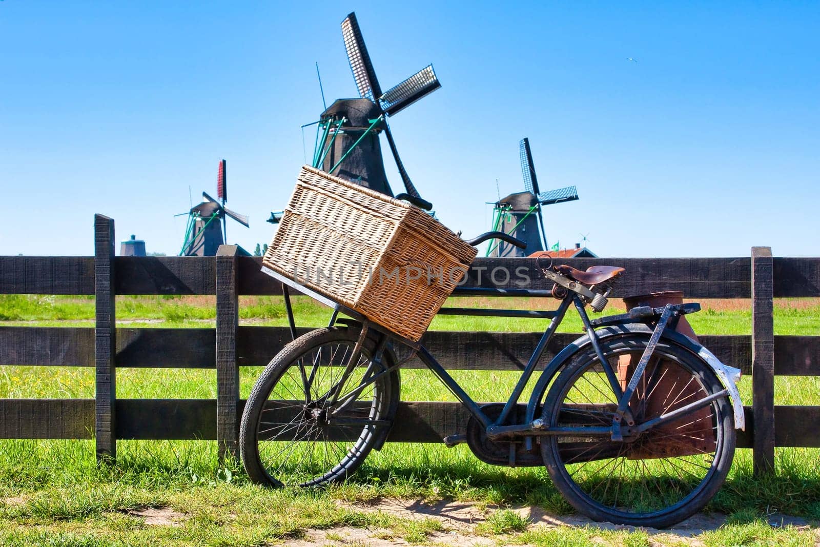 Bicycle with windmill and blue sky background. Scenic countryside landscape close to Amsterdam in Netherlands.