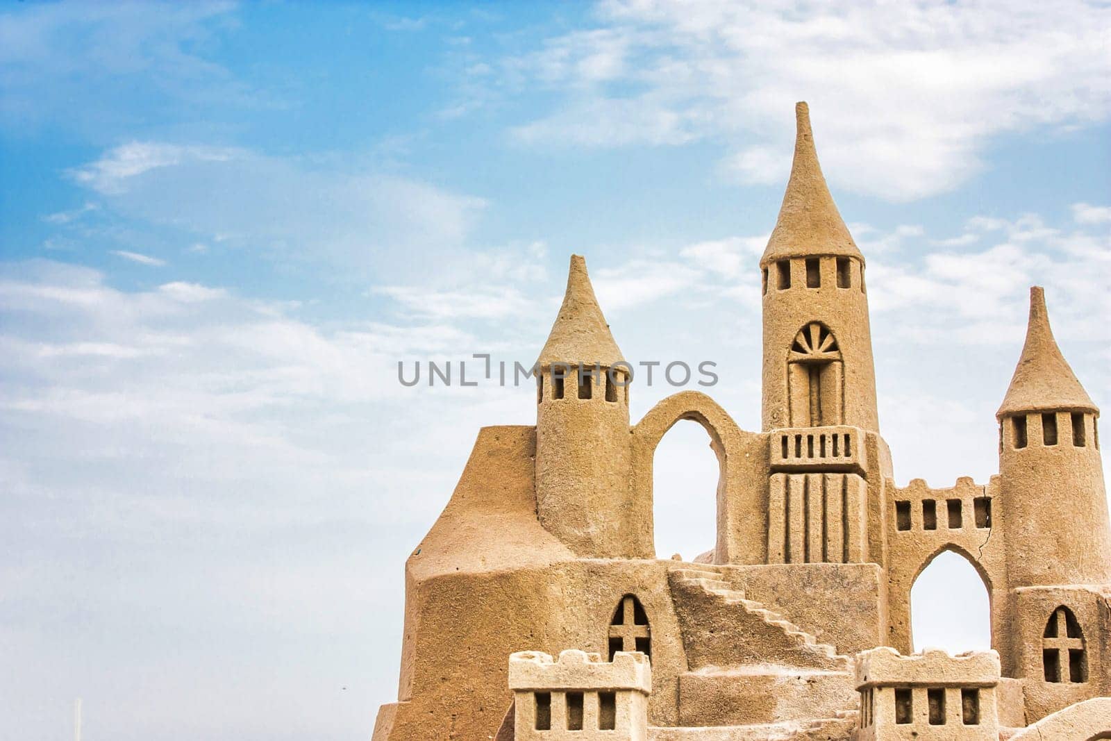 Sandcastle during a sunny day with blue sky background. Concept for summer, vacation, relax and fun.