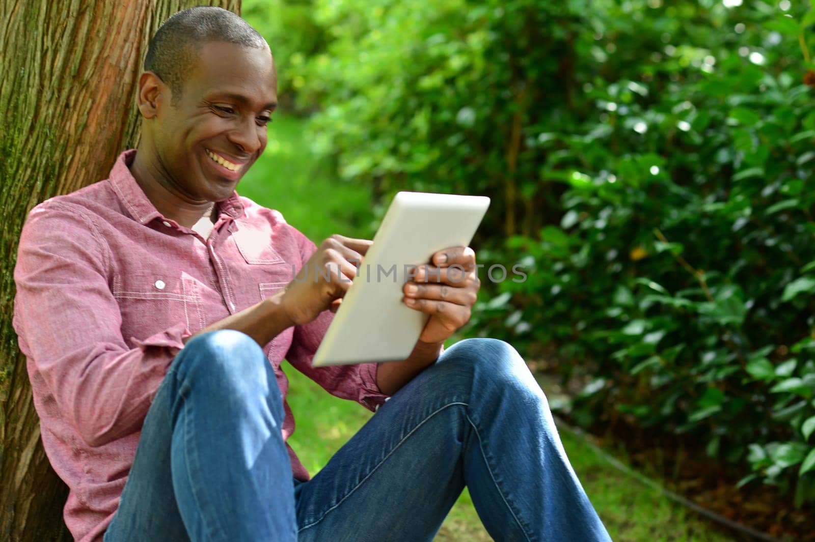 Happy man watching social media in a digital tablet