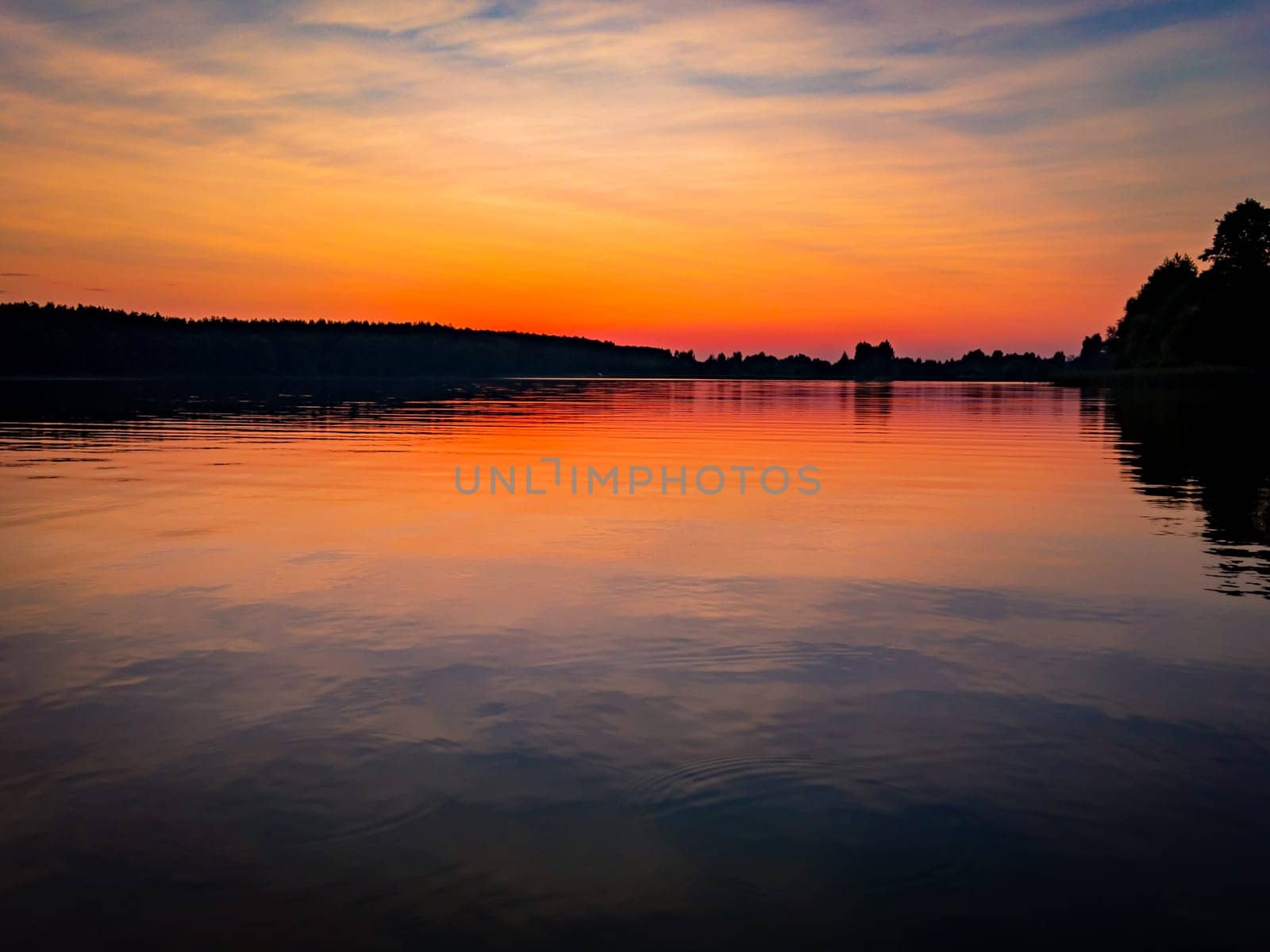 Sunset at lake, sky with clouds in background and pier in foreground
