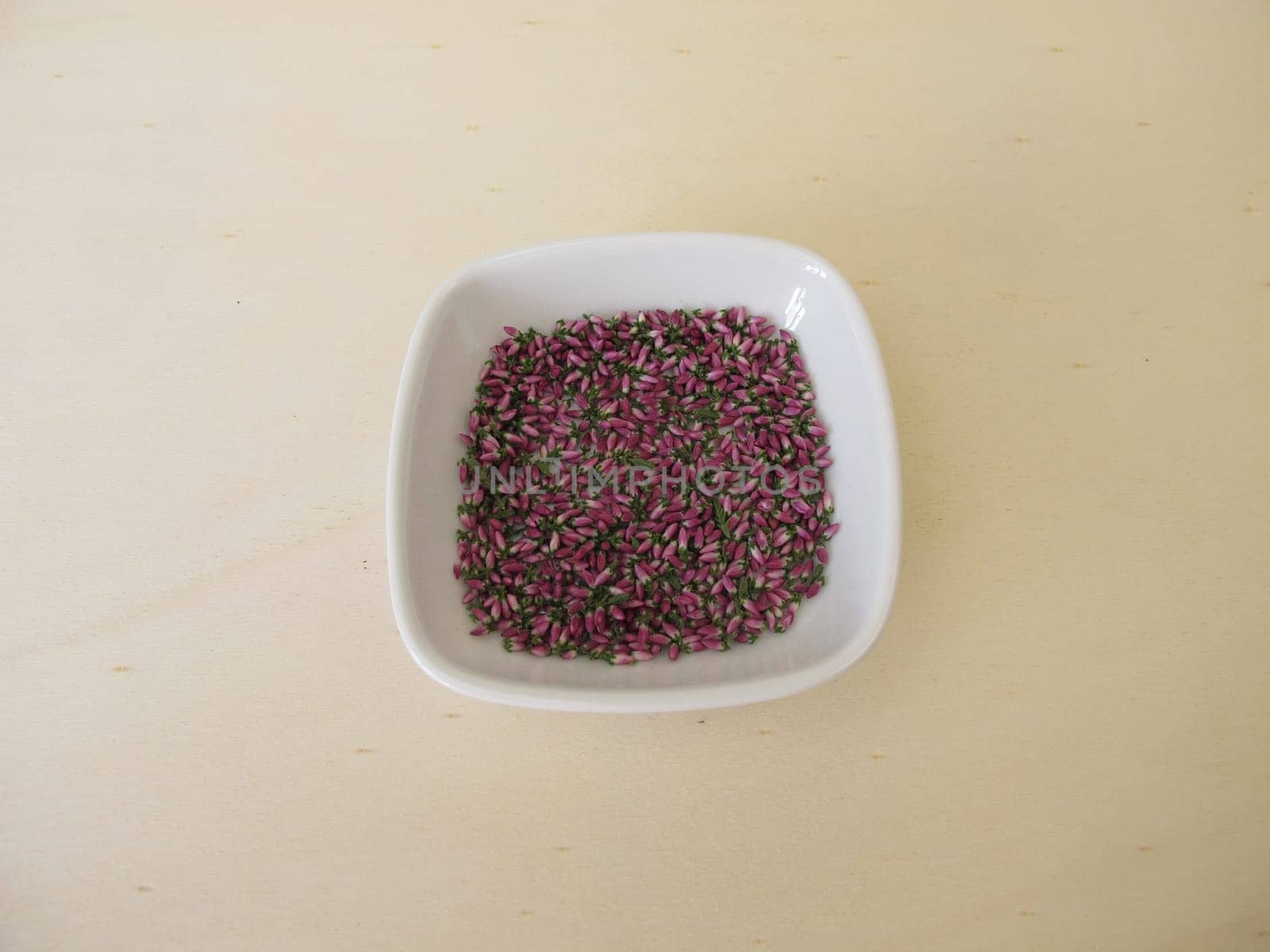 Dried pink heather flowers on a wooden board