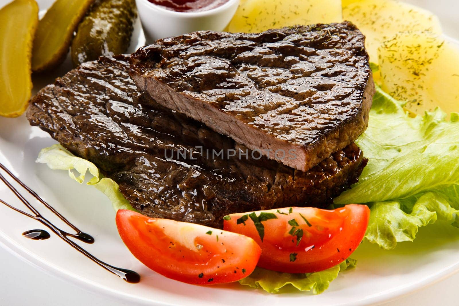 Grilled steaks, French fries and vegetables