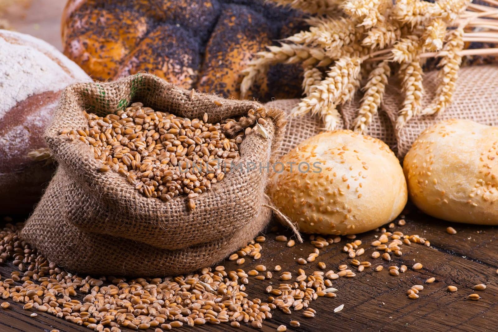 Assortment of baked bread on wooden table background