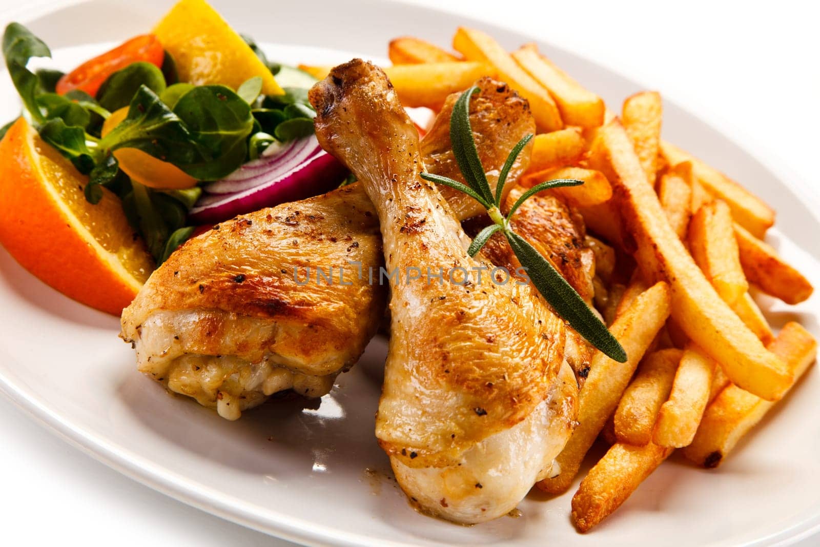 Grilled chicken legs with chips and vegetables