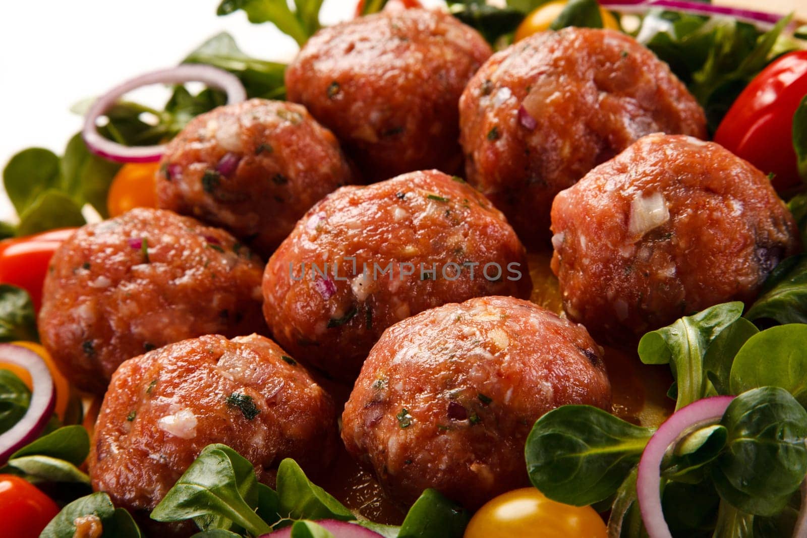 Raw meatballs on cutting board on white background