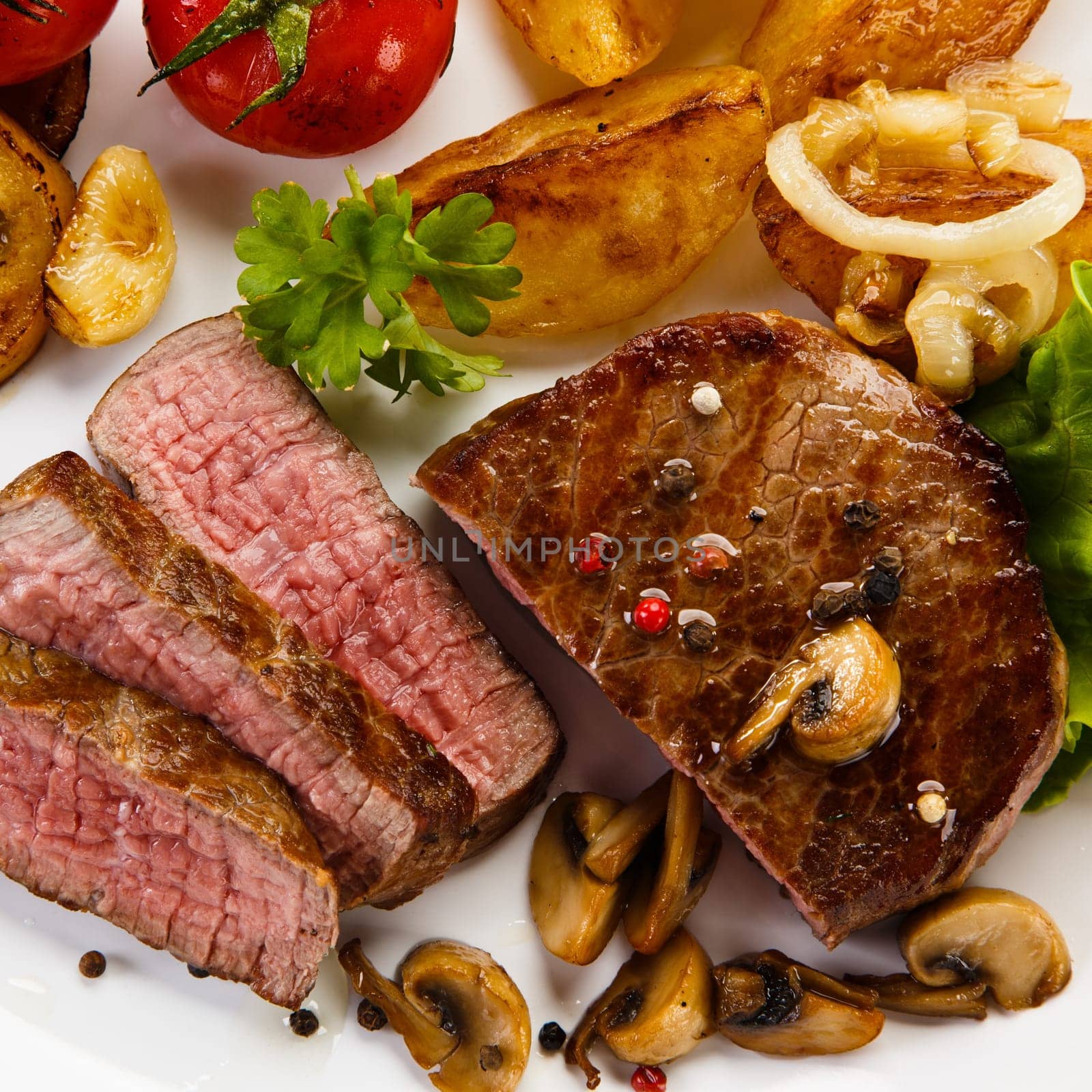 Steaks, baked potatoes and vegetable salad