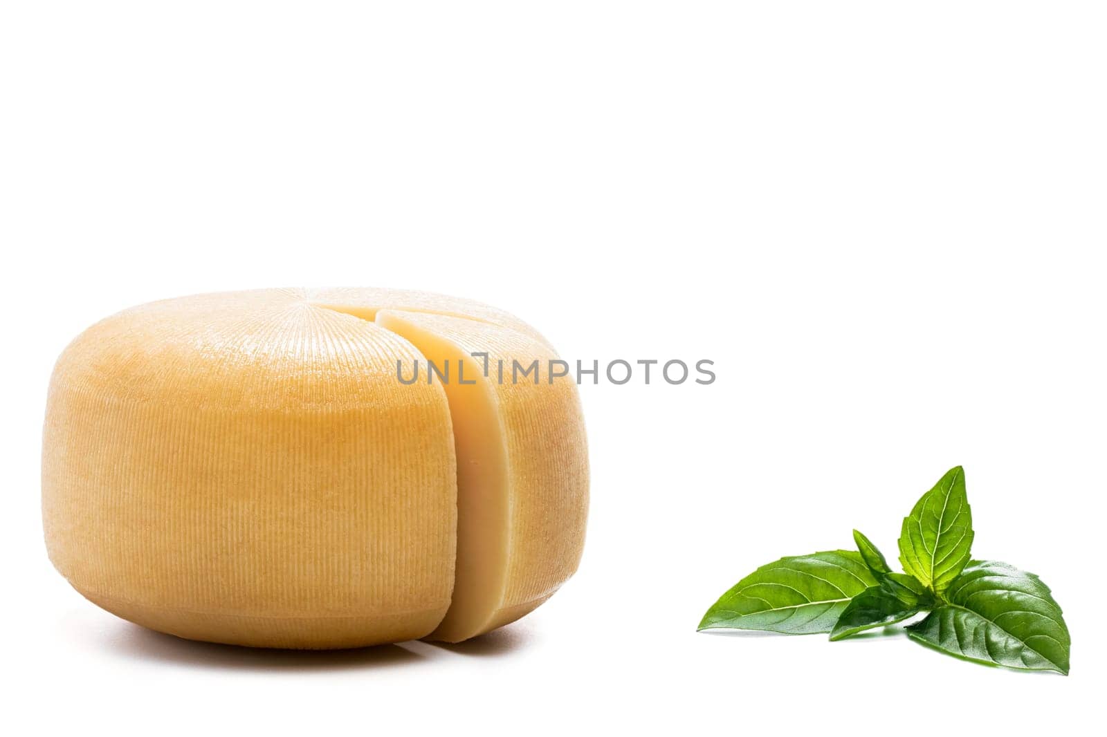 Yellow round cheese and basil leaves on white background