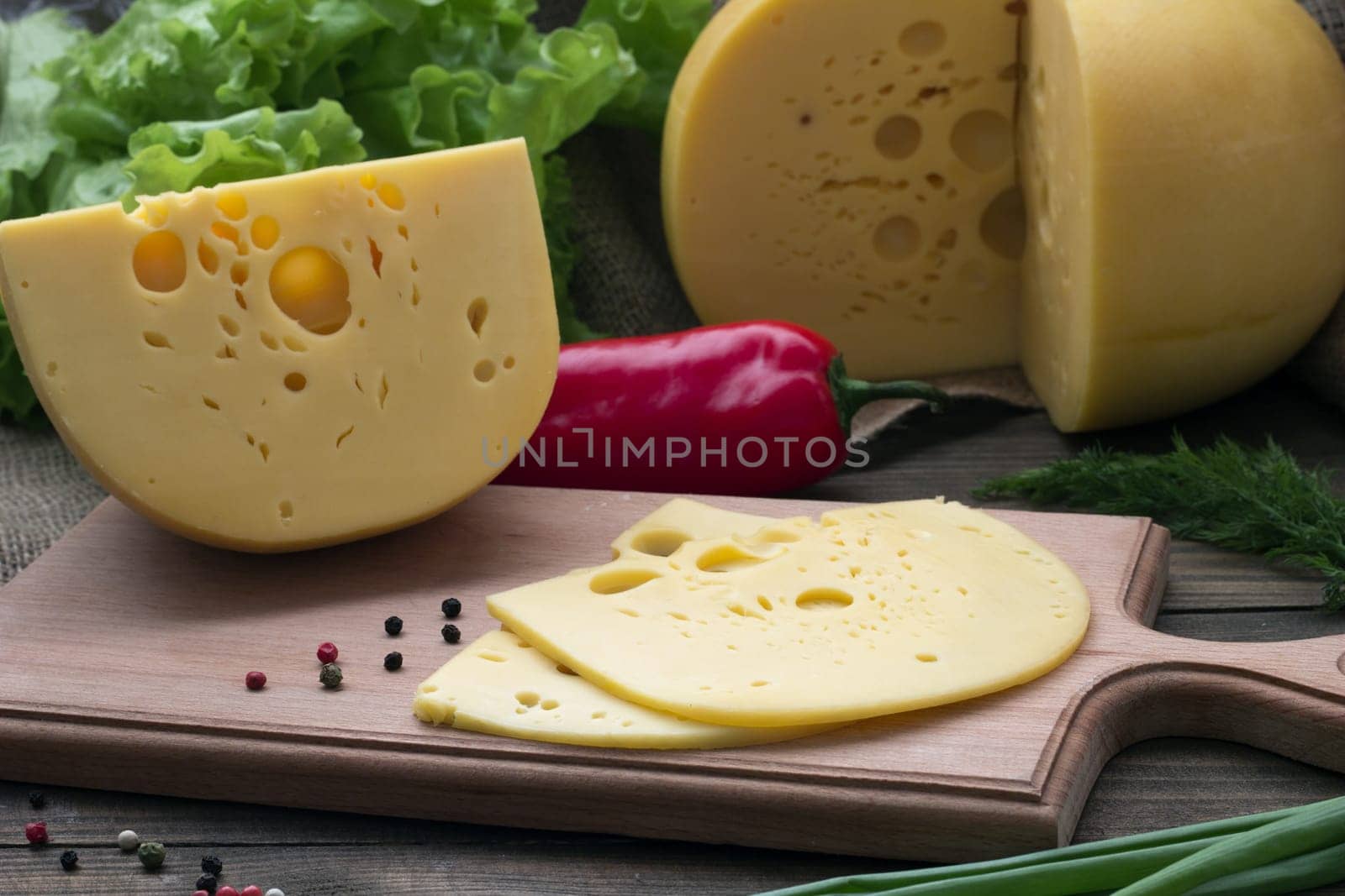 Cheese Chopped and whole , fresh herbs and pepper on the table