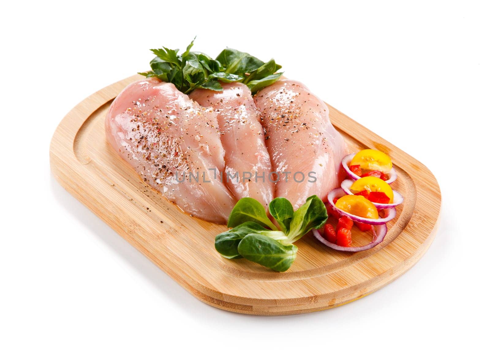 Raw pork chops on cutting board and vegetable
