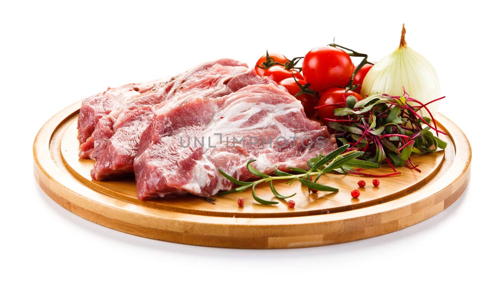 Raw pork chops on cutting board and vegetable