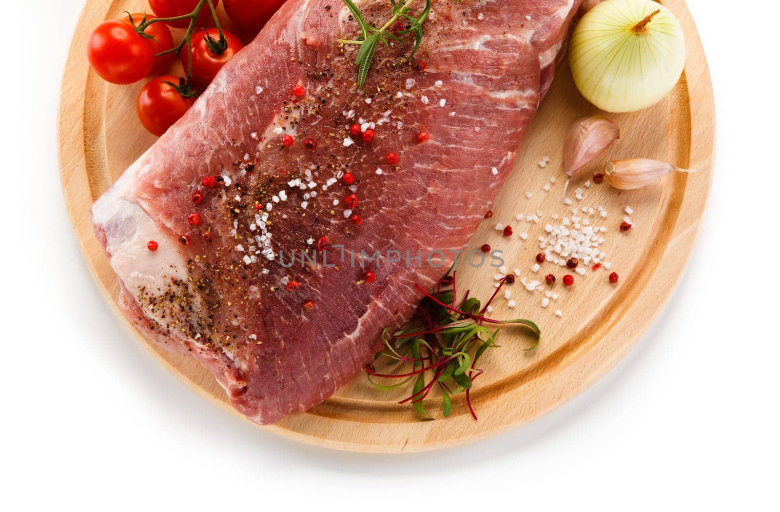 Raw pork chops on cutting board and vegetable