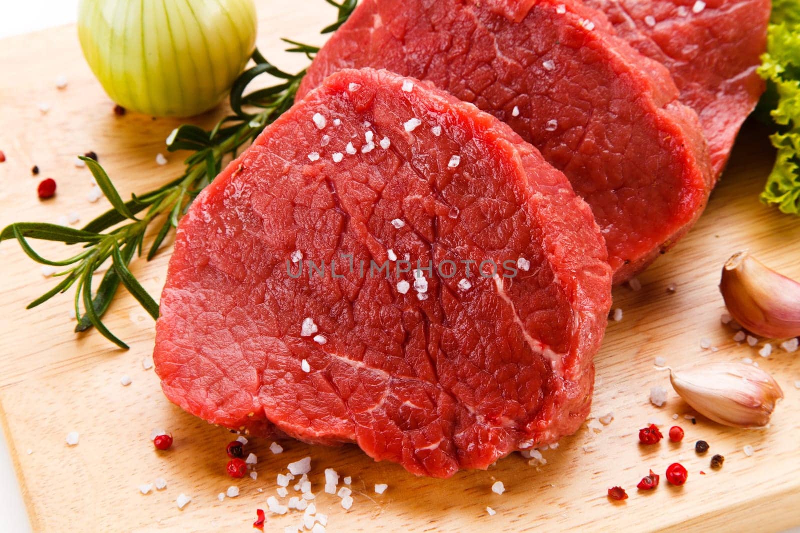 Raw pork chops on cutting board and vegetable