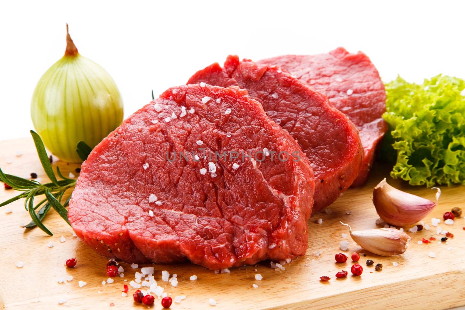 Raw pork chops on cutting board and vegetable