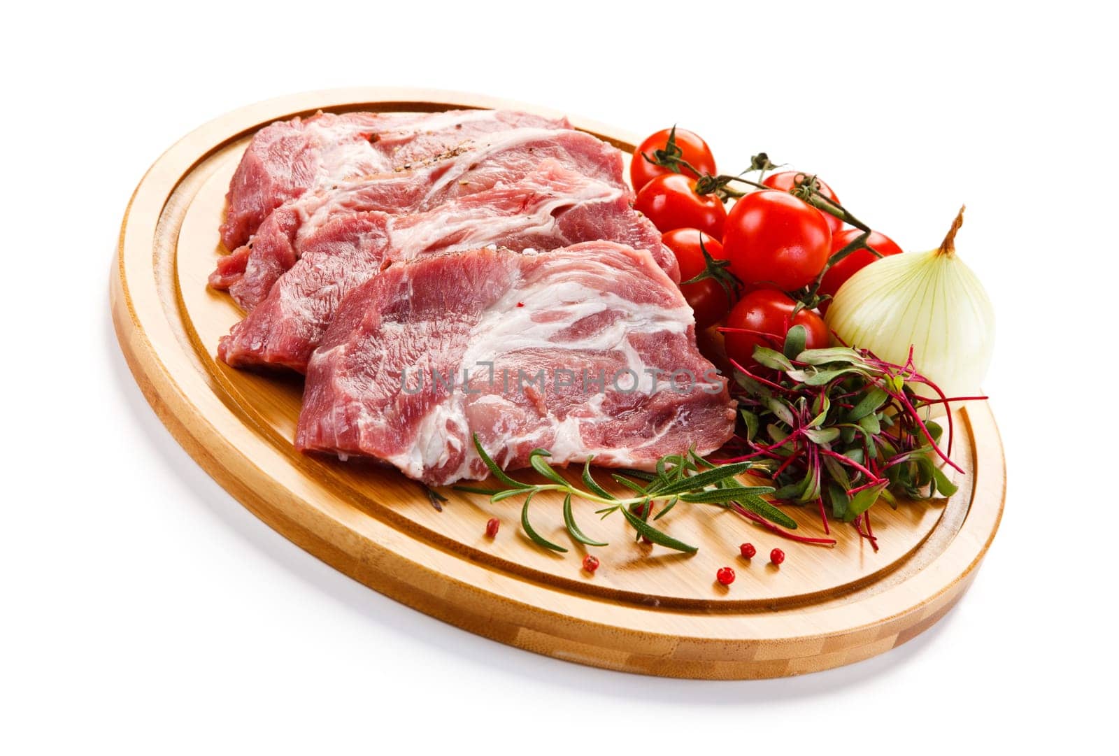 Raw pork chops on cutting board and vegetable
