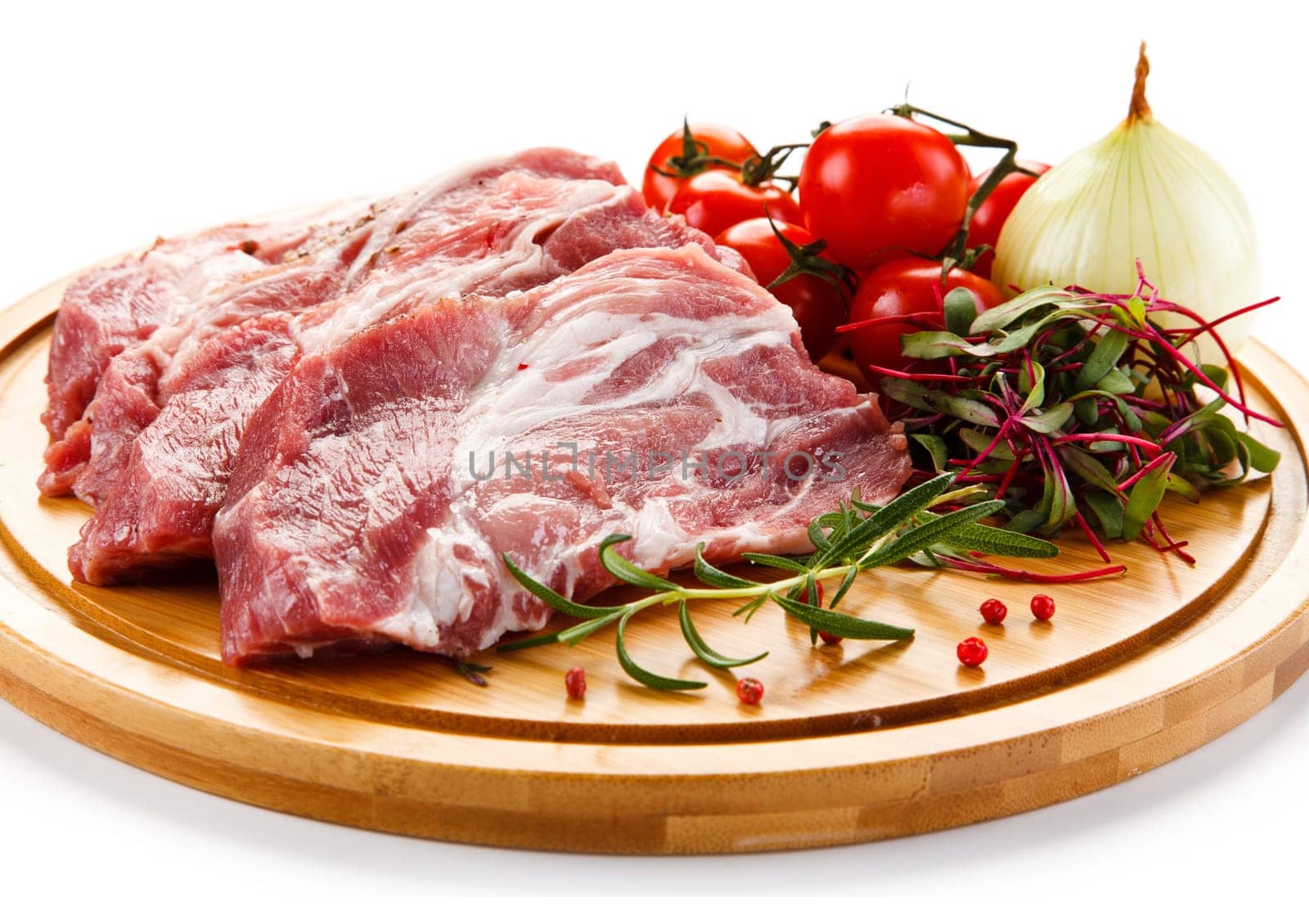 Raw pork chops on cutting board and vegetable