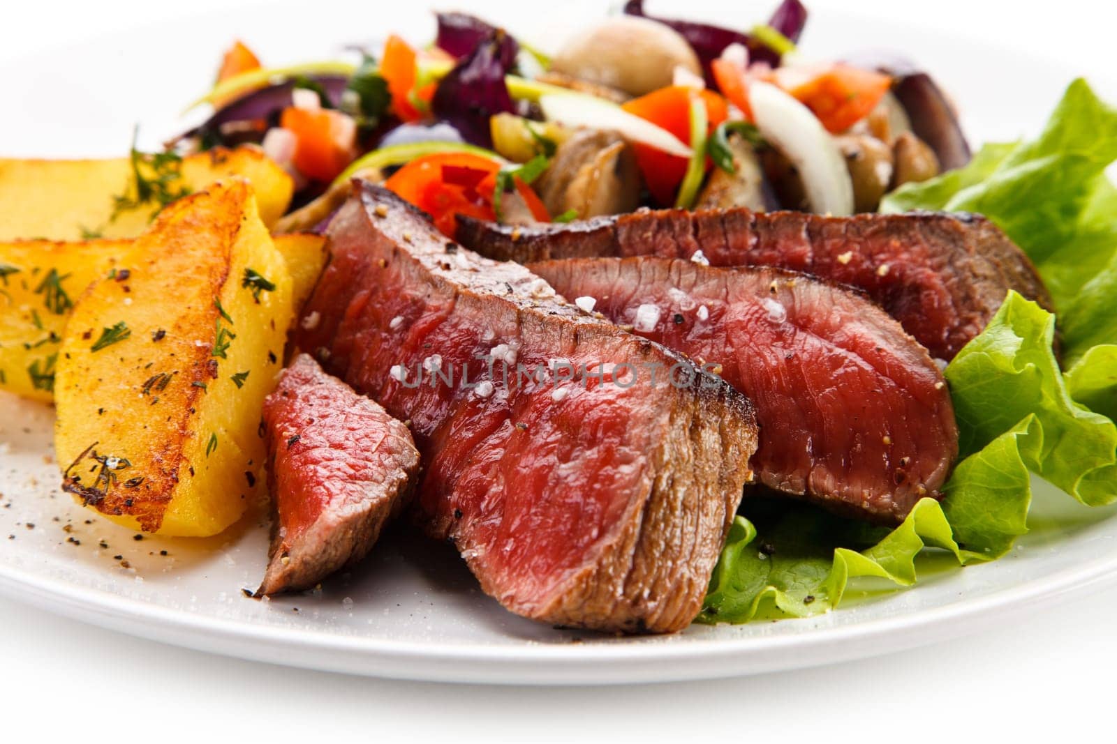 Steaks, baked potatoes and vegetable salad