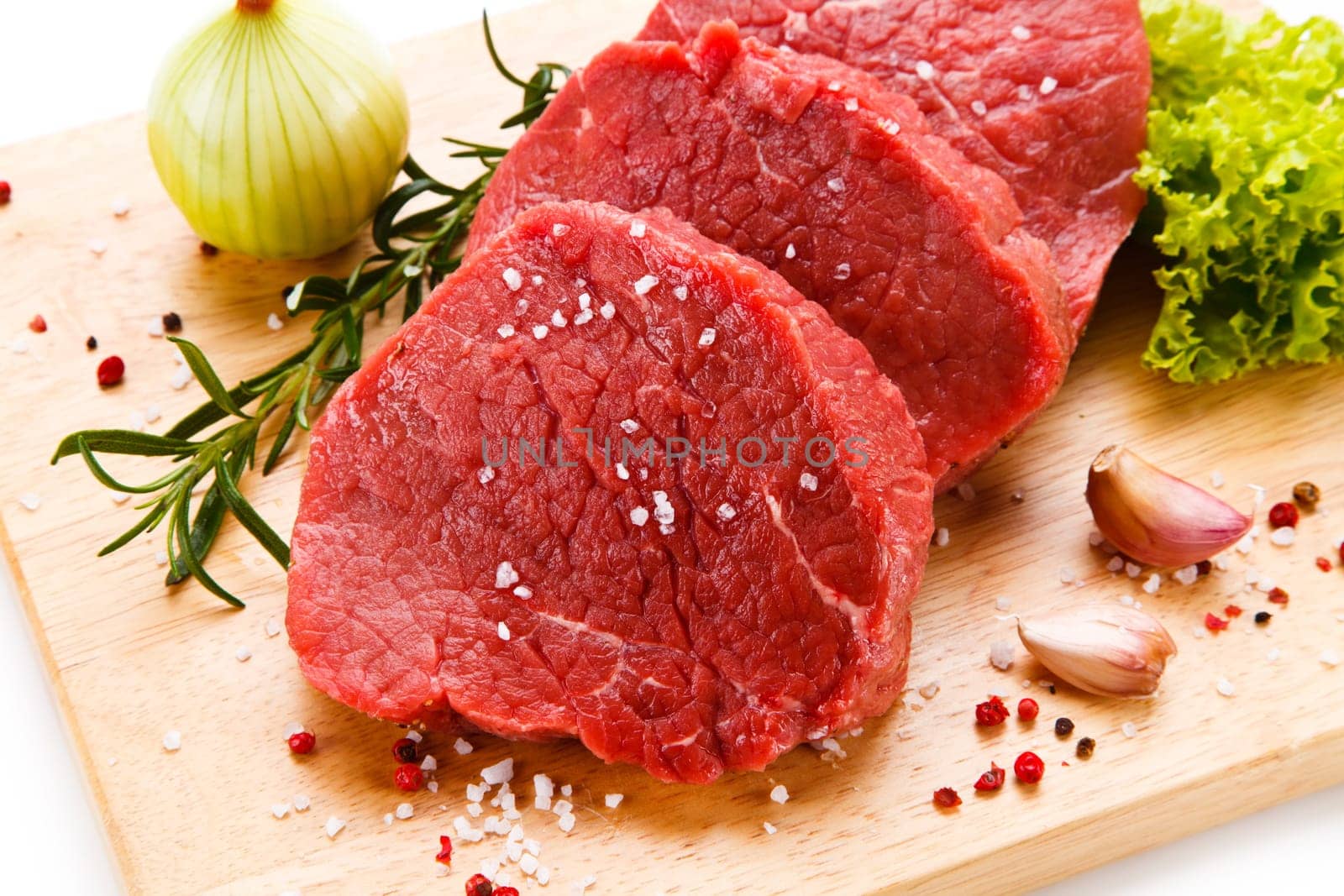Raw pork chops on cutting board and vegetable