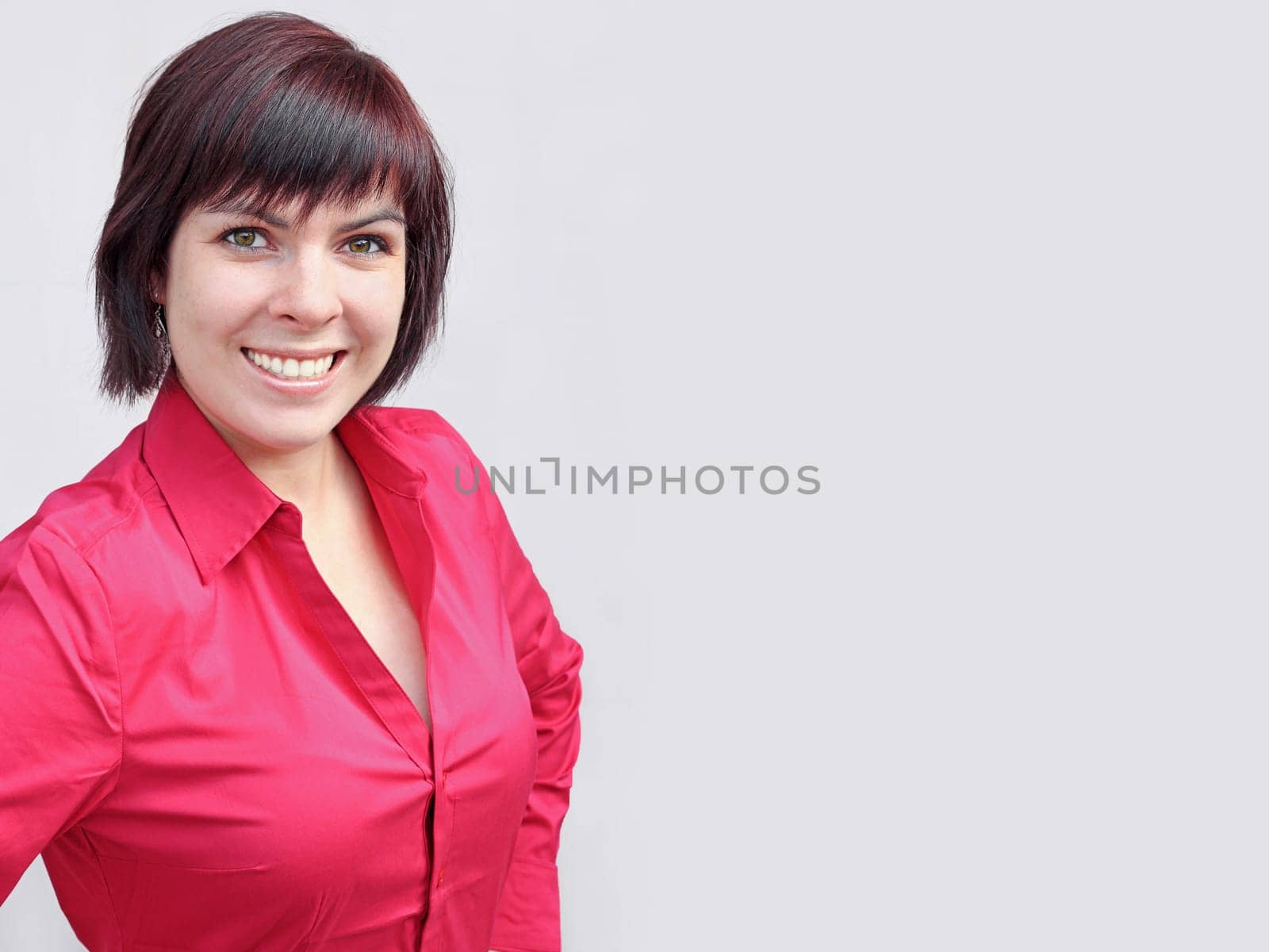 A redhead, pretty, laughing, young, sympathetic woman in a red blouse
