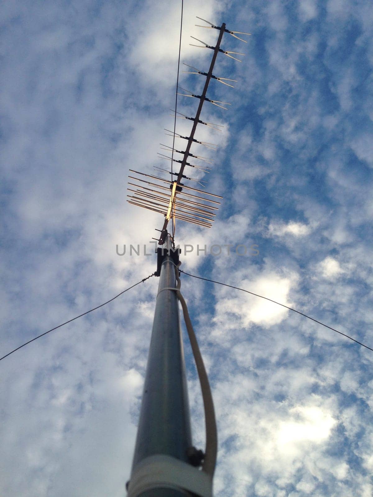 Domestic Tv antenna over blue cloudy sky. Selective focus