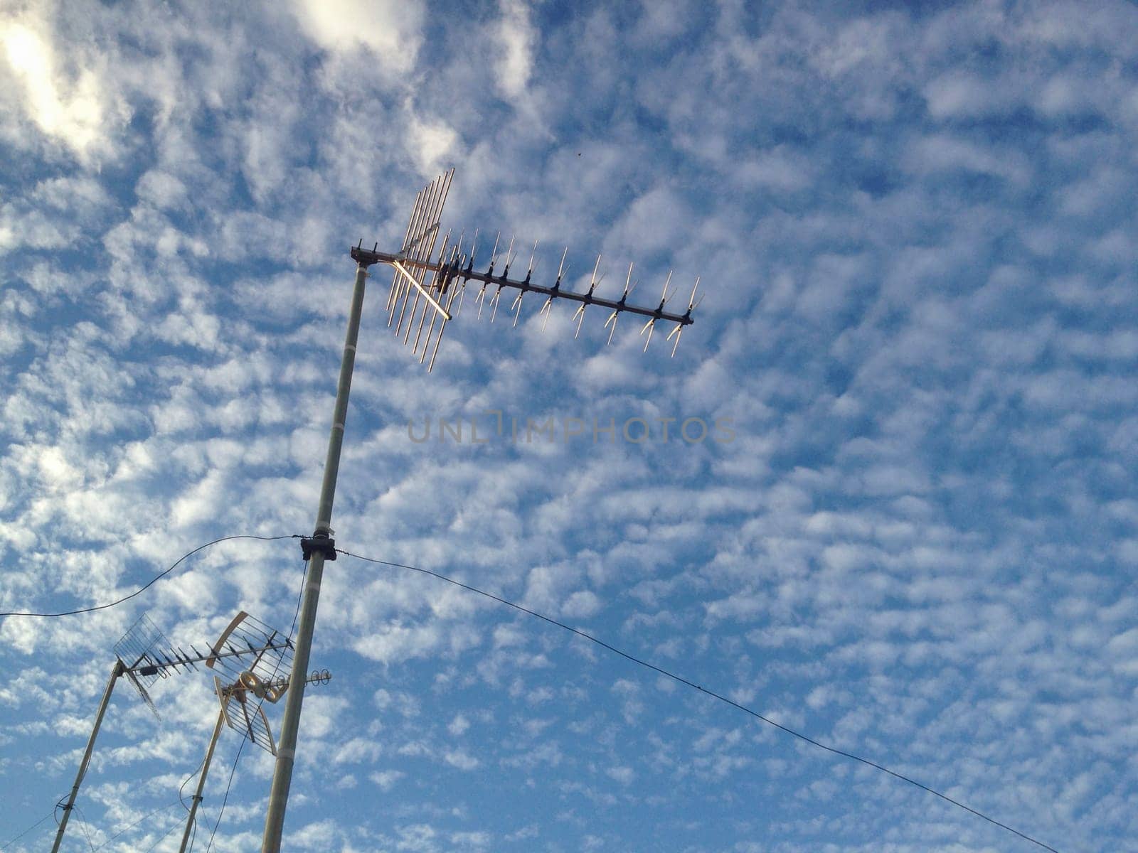 Domestic Tv antennas over blue cloudy sky. Selective focus