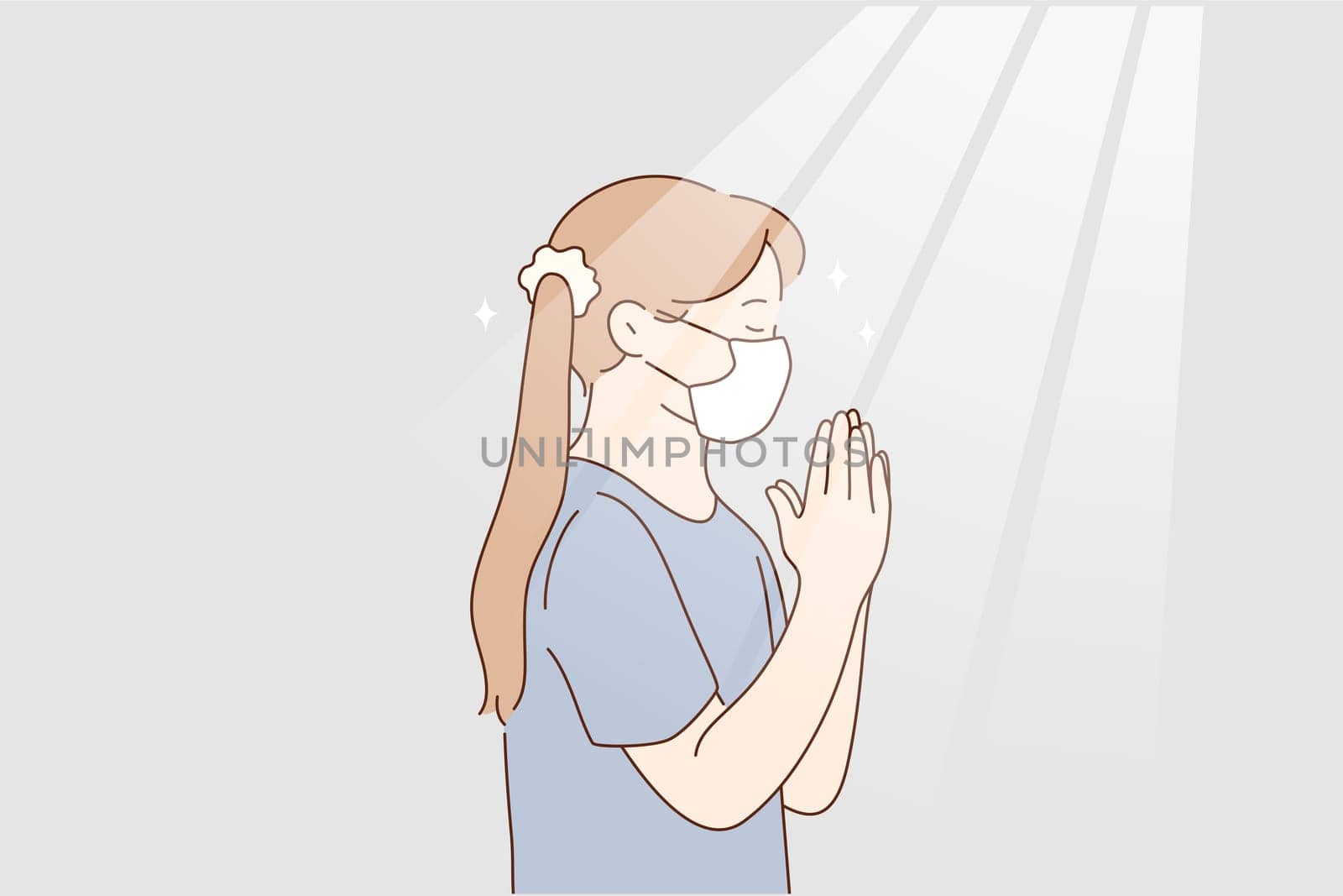 Little girl praying at home during pandemic concept. Little girl in protective medical mask from coronavirus infection staying and playing god with eyes closed hoping to stop infection worldwide