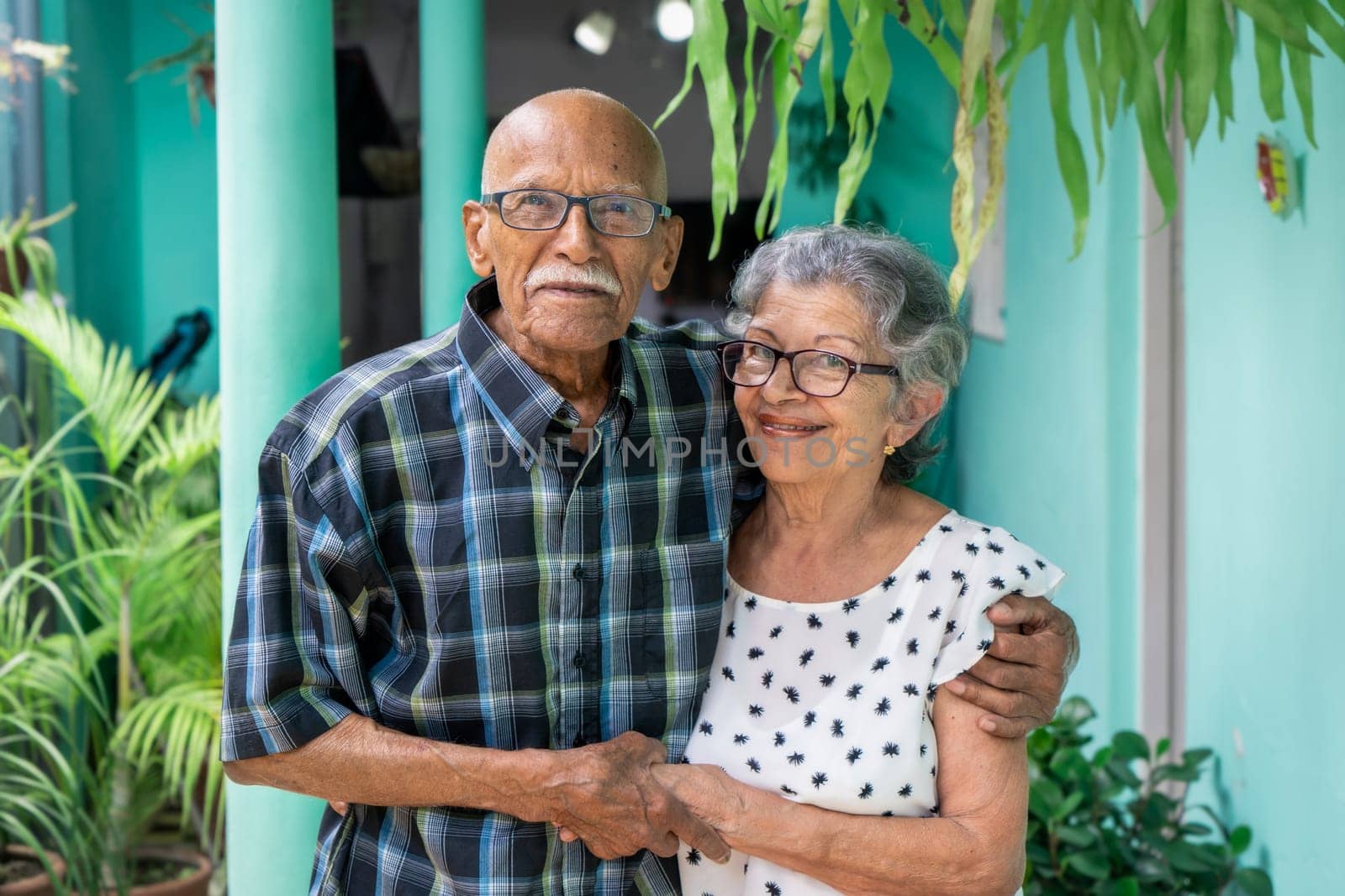 Elderly couple embracing and smiling looking at the camera