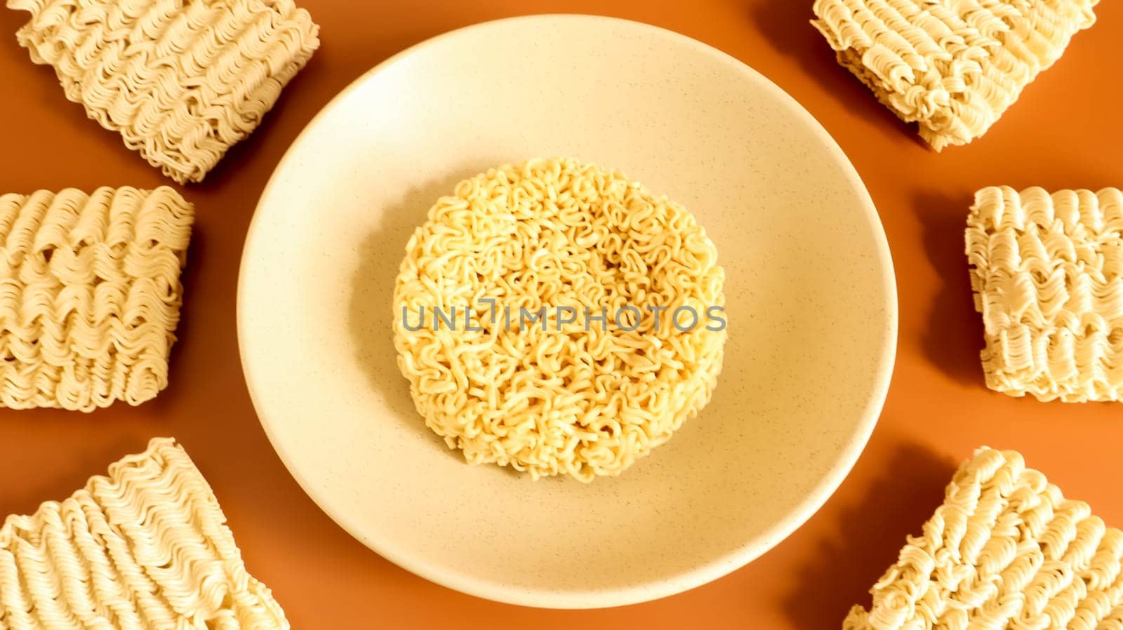 Raw dry instant noodles in a deep ceramic beige soup bowl on a brown background. pasta, for the preparation of which it is enough to pour boiling water and wait a few minutes. Copy space.