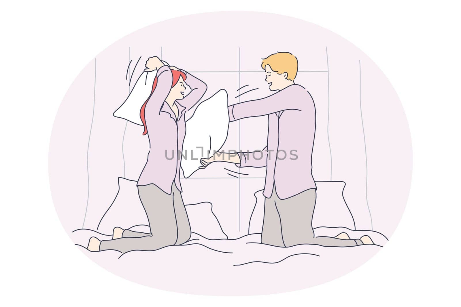 Pillow fighting and battle concept. Young happy couple fighting with pillows in bed and having fun during funny cheerful jaunt pastime together at home