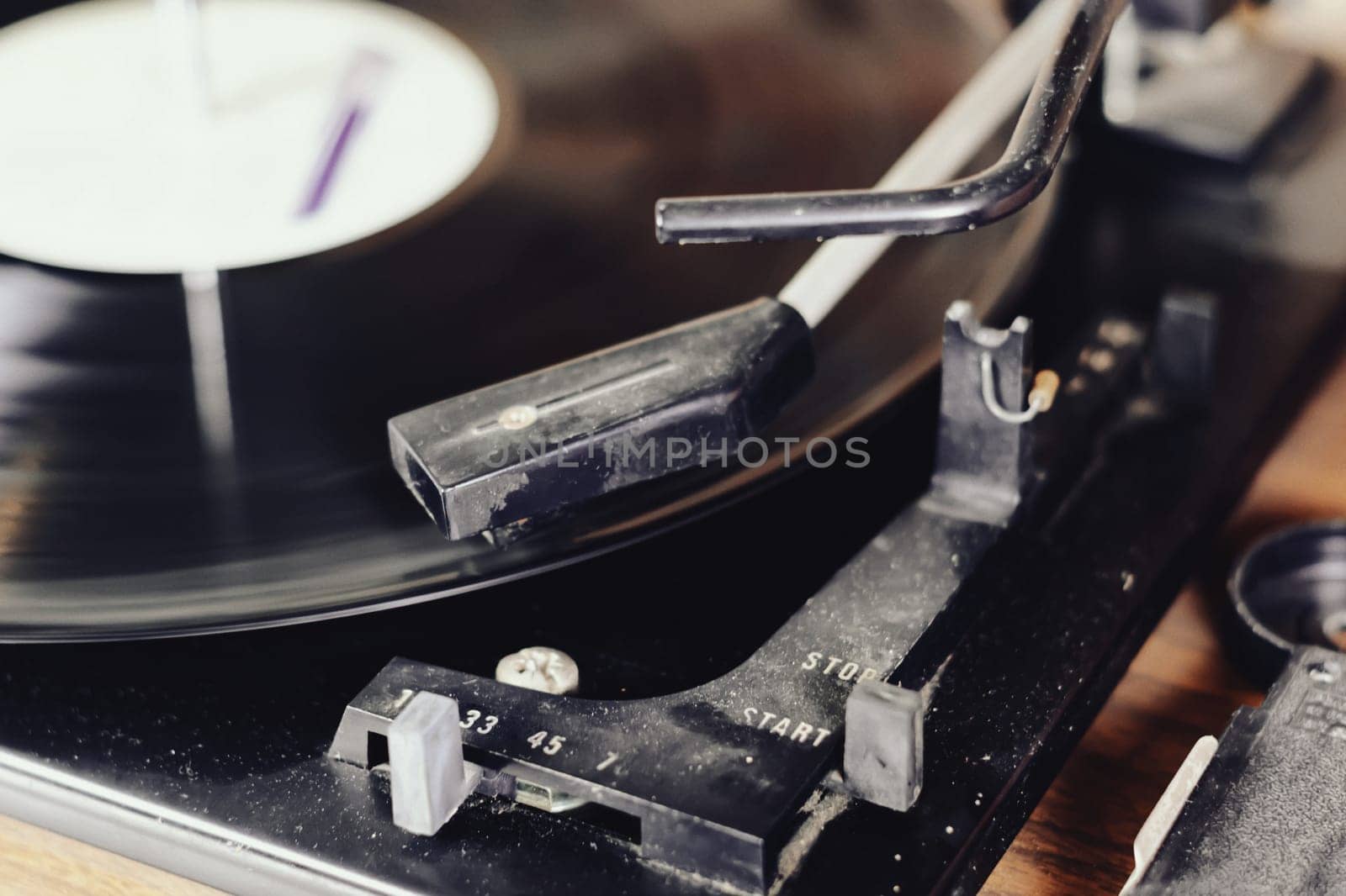 the needle of a turntable playing the tracks of a black vinyl record. Vintage audio equipment. Vinyl record player
