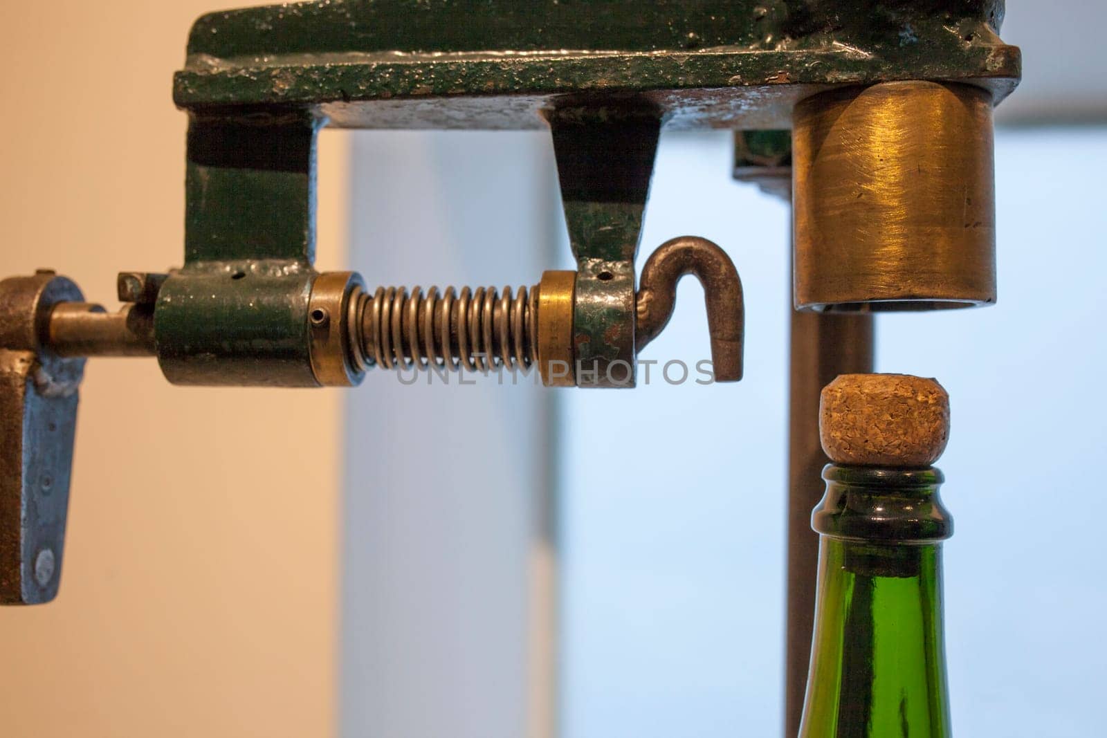 Old corking machine with cava bottle. Closeup