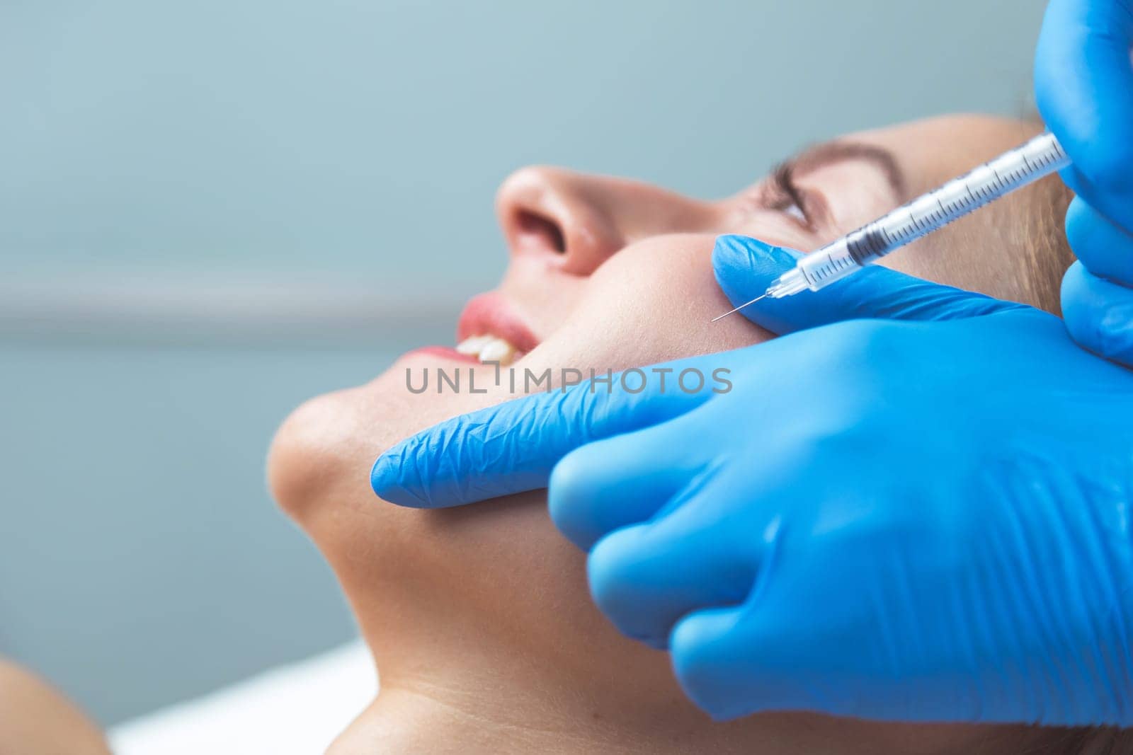 Rejuvenating facial injections procedure for tightening and smoothing wrinkles on the face skin of a beautiful, young woman in a beauty salon.Cosmetology skin care.