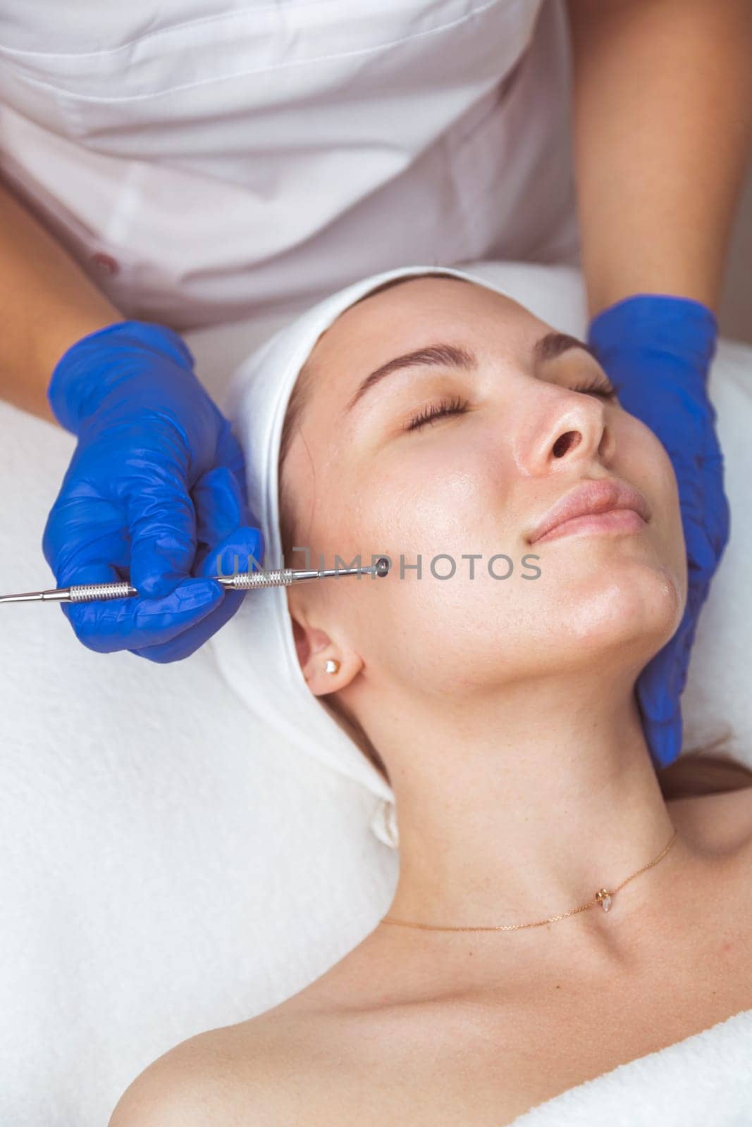 Beautician using professional multiple hole spoon to clean cleansing face and pores