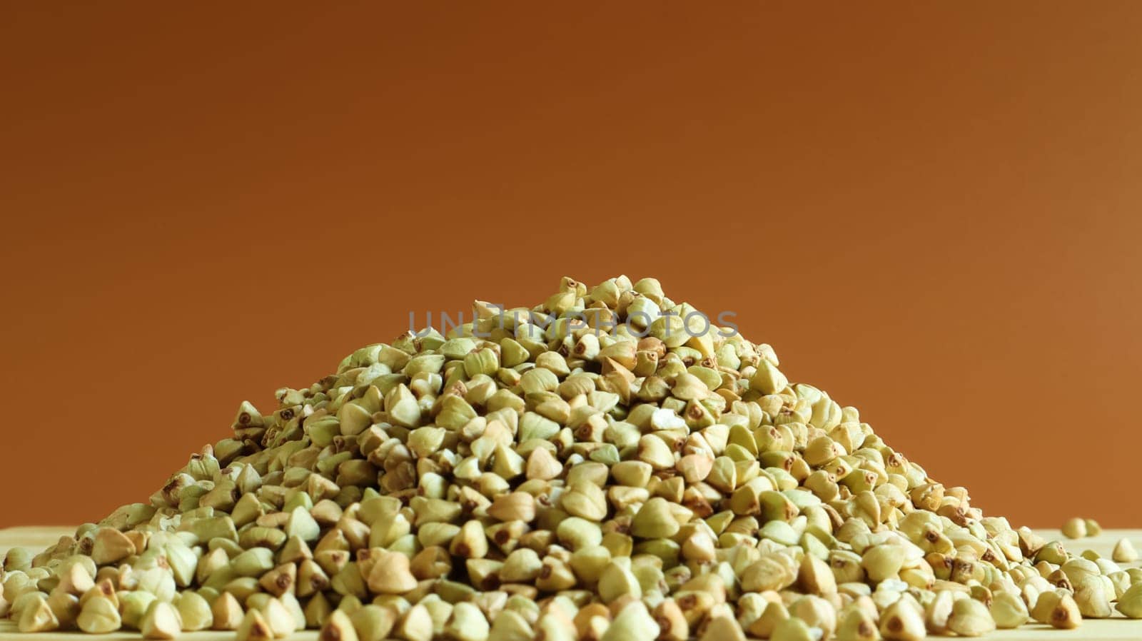 Green buckwheat seeds on a wooden background. Great food. healthy groats. Organic raw non-fried vegetarian food. The concept of a healthy, balanced and dietary diet. Copy space