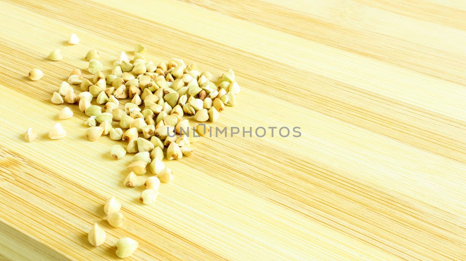 Green buckwheat seeds on a wooden background. Great food. healthy groats. Organic raw non-fried vegetarian food. The concept of a healthy, balanced and dietary diet. Copy space