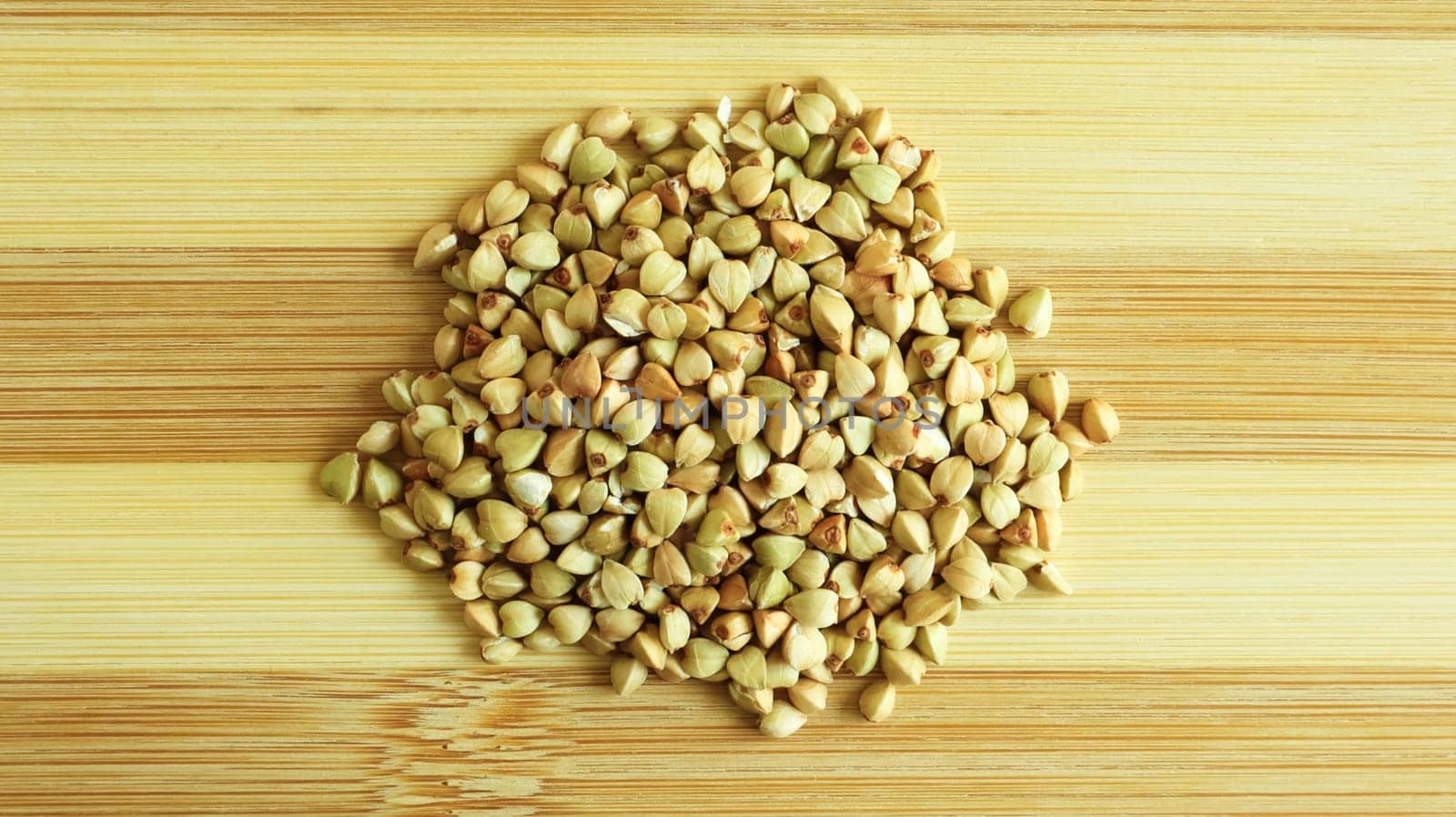 Green buckwheat seeds on a wooden background. Great food. healthy groats. Organic raw non-fried vegetarian food. The concept of a healthy, balanced and dietary diet. Copy space