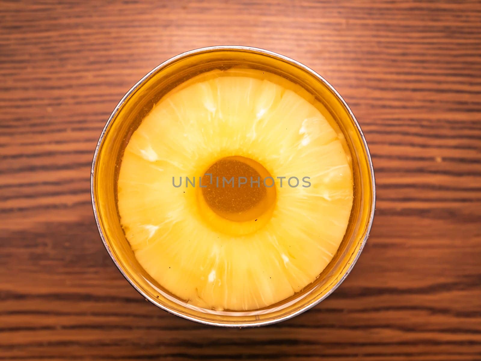 Sliced pineapple in a tin can with juice. Food photo. Place for text.